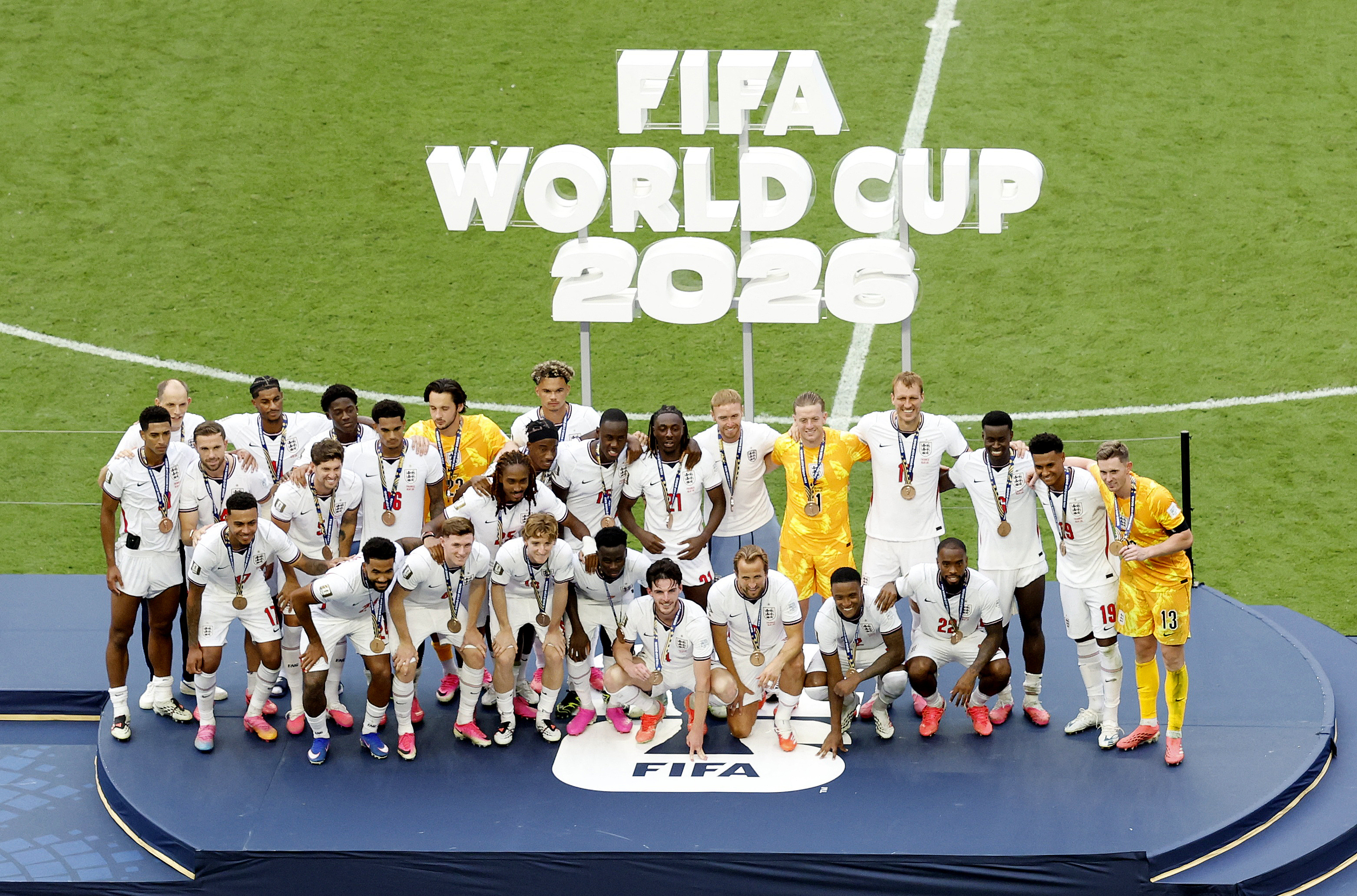 England manager Thomas Tuchel and England players wear their bronze medals as they pose for a picture on the podium during the ceremony after the match