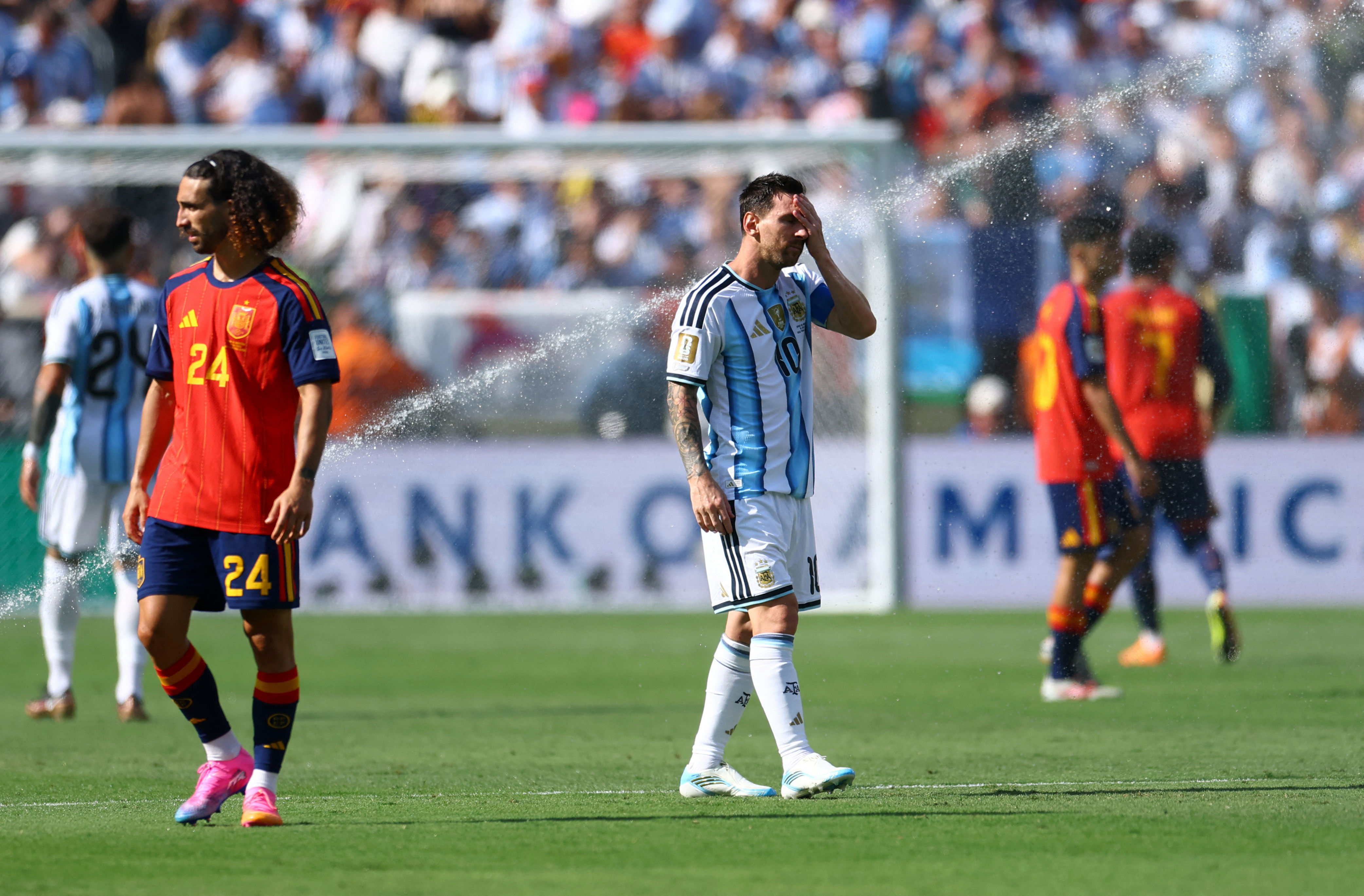Argentina’s Lionel Messi, centre, and Spain’s Marc Cucurella, left, during the final’s second-half hydration break