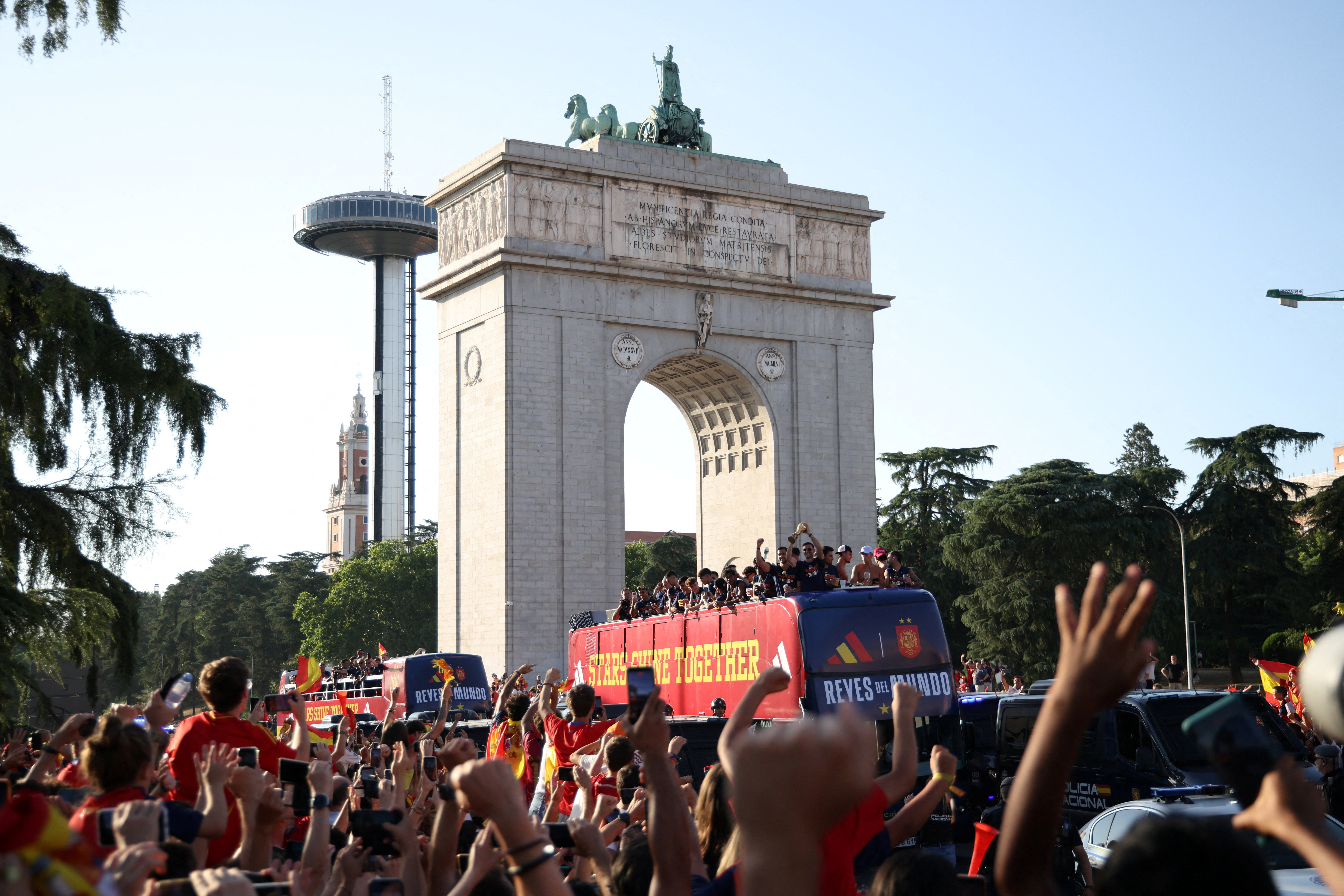 Spain players celebrate with the World Cup trophy during the victory parade as the Arco de la Victoria is seen in the background