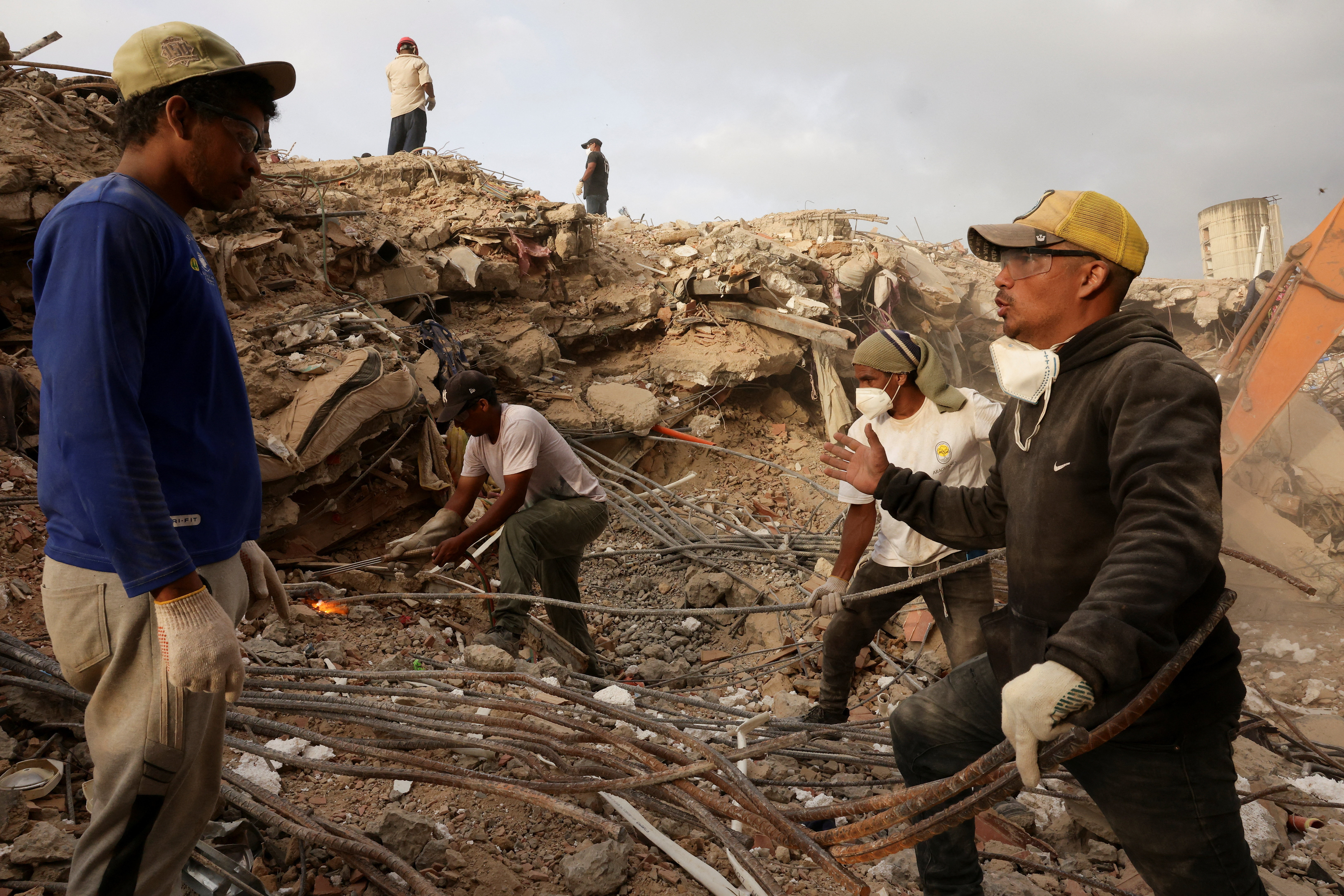 People work together as they search for their loved ones amid debris, in the aftermath of the June 24 earthquakes in Caraballeda, La Guaira, Venezuela, July 20, 2026. REUTERS/Gaby Oraa