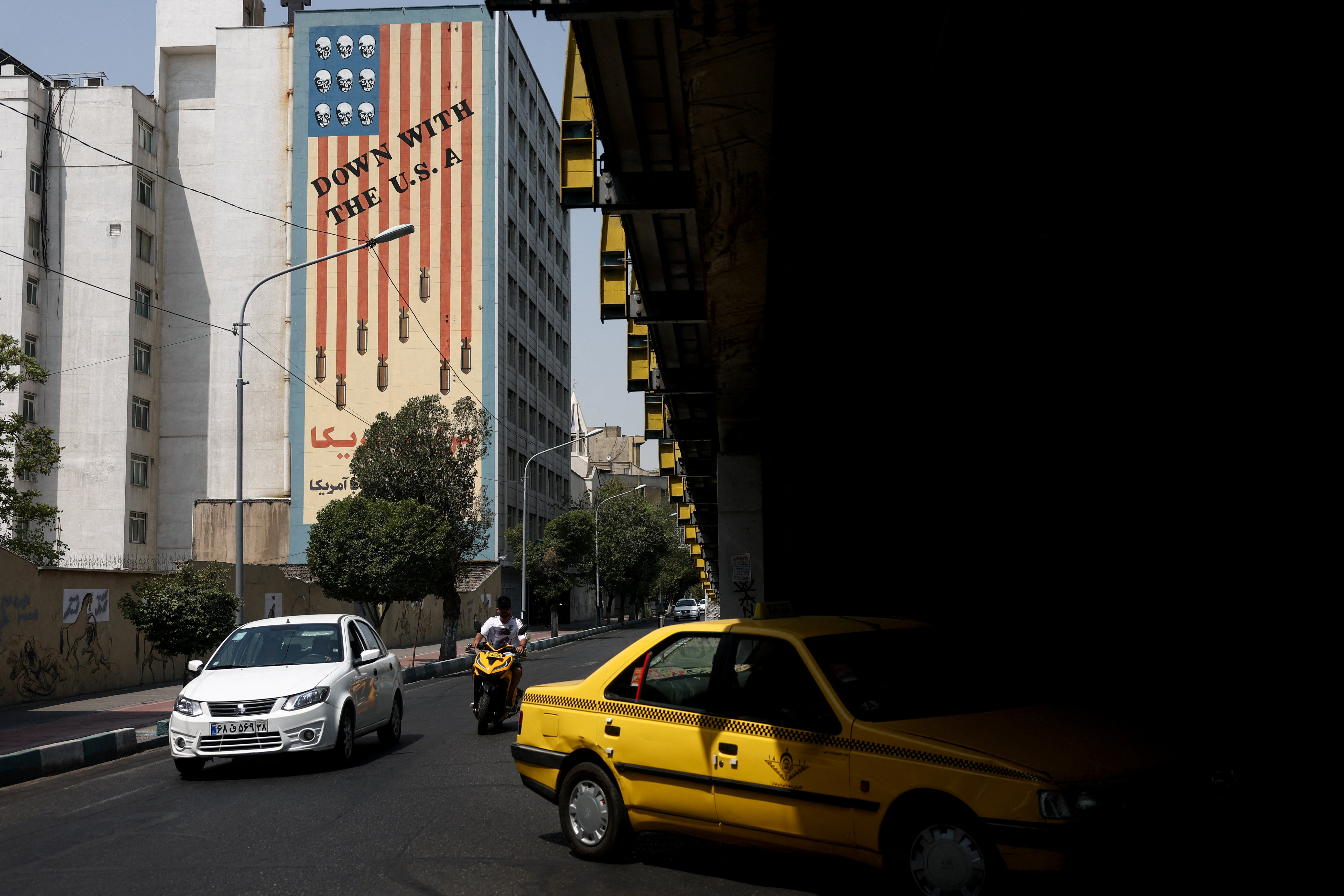 People drive near an anti-US mural in Tehran, Iran, July 23, 2026. [Majid Asgaripour/WANA via Reuters]