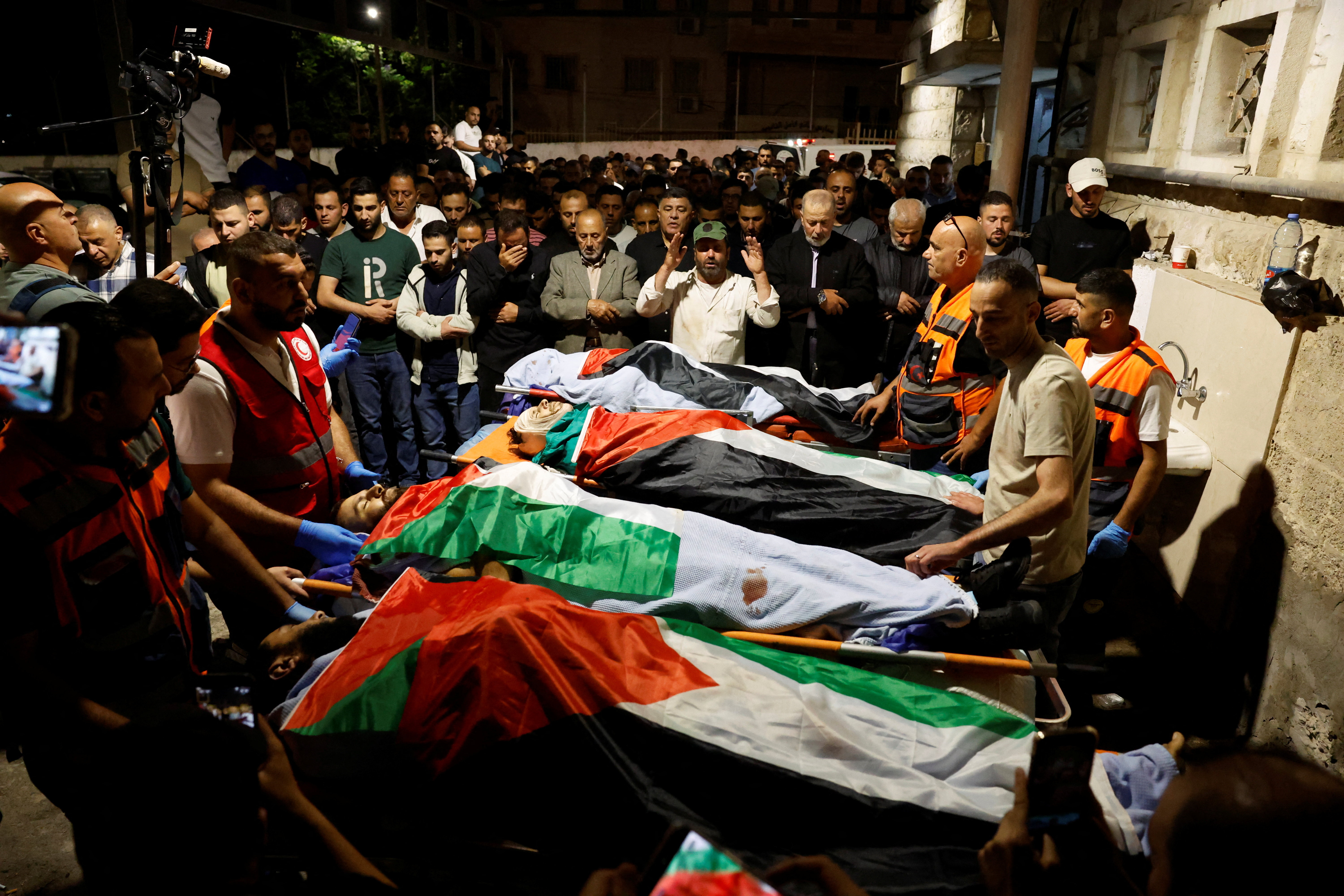 Palestinians pray next to the bodies of Palestinians during their funeral who were killed in a deadly shooting incident, according to Israeli and Palestinian health officials, near the village of Tal, in Nablus, in the Israeli-occupied West Bank, July 25, 2026. REUTERS/Mohammed Torokman