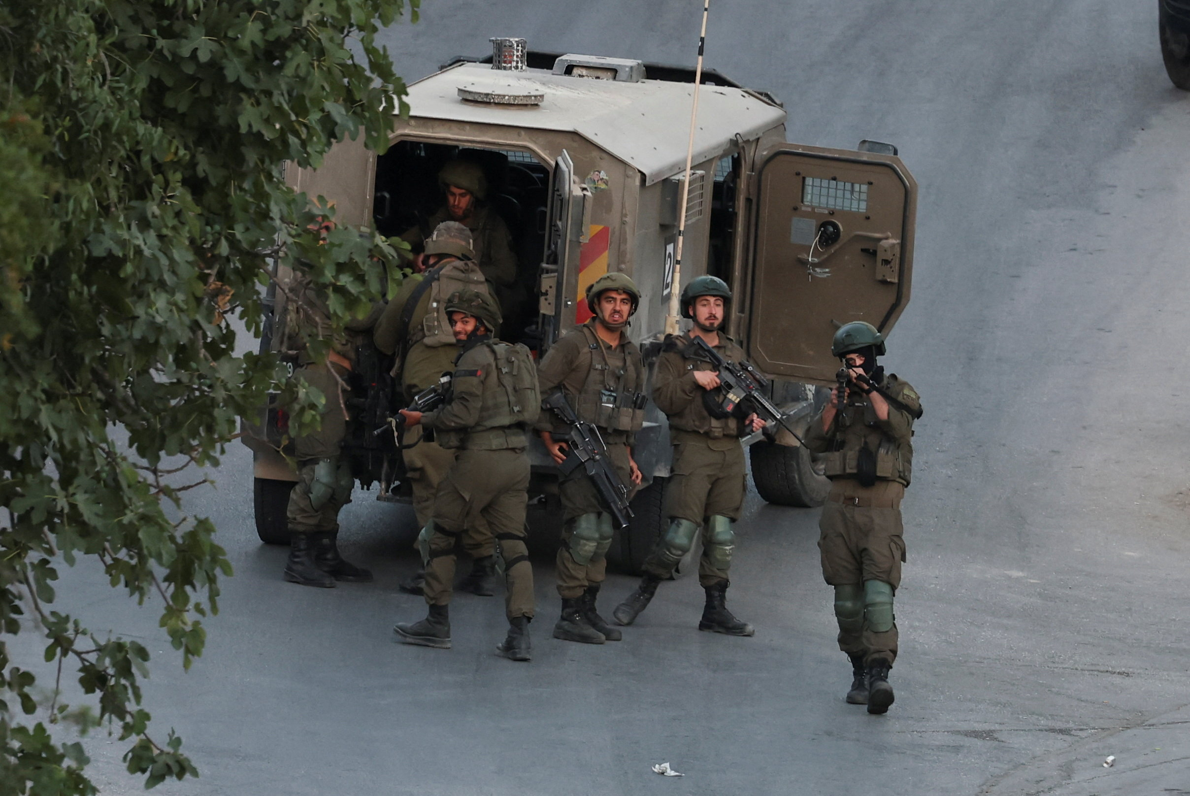 Israeli soldiers stand by a military vehicle at the Palestinian village of Tal in the Israeli-occupied West Bank, July 31, 2026. REUTERS/Ammar Awad