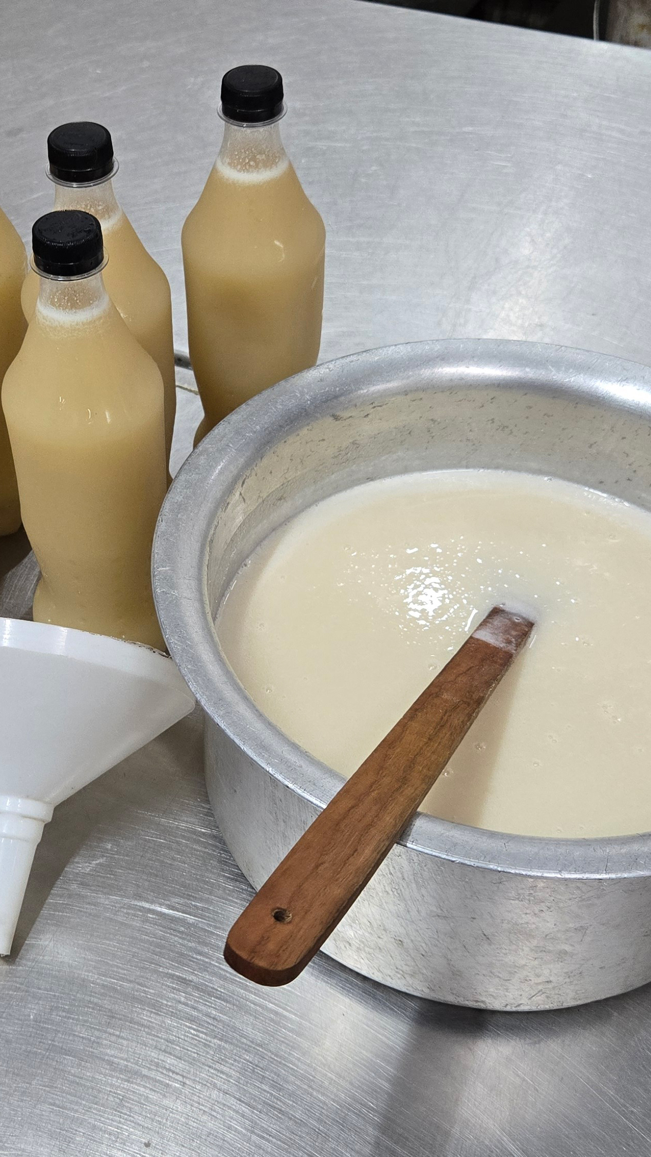 The fresh almond concentrate is passed through a funnel before being bottled as orchata
