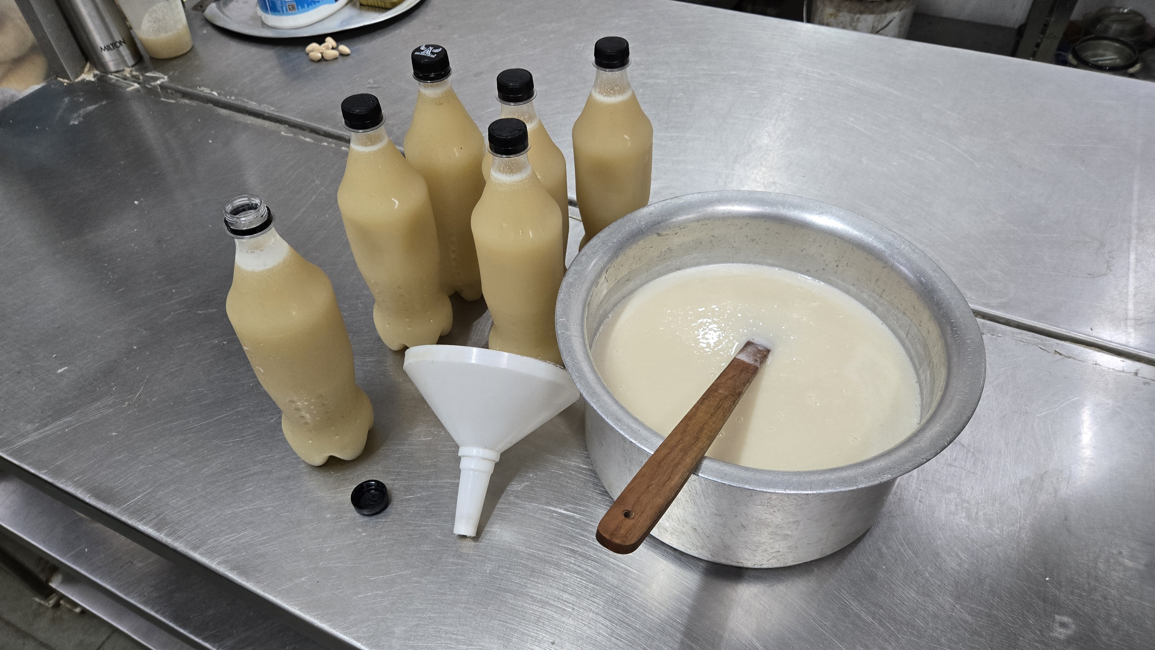 The fresh almond concentrate is passed through a funnel before being bottled as orchata