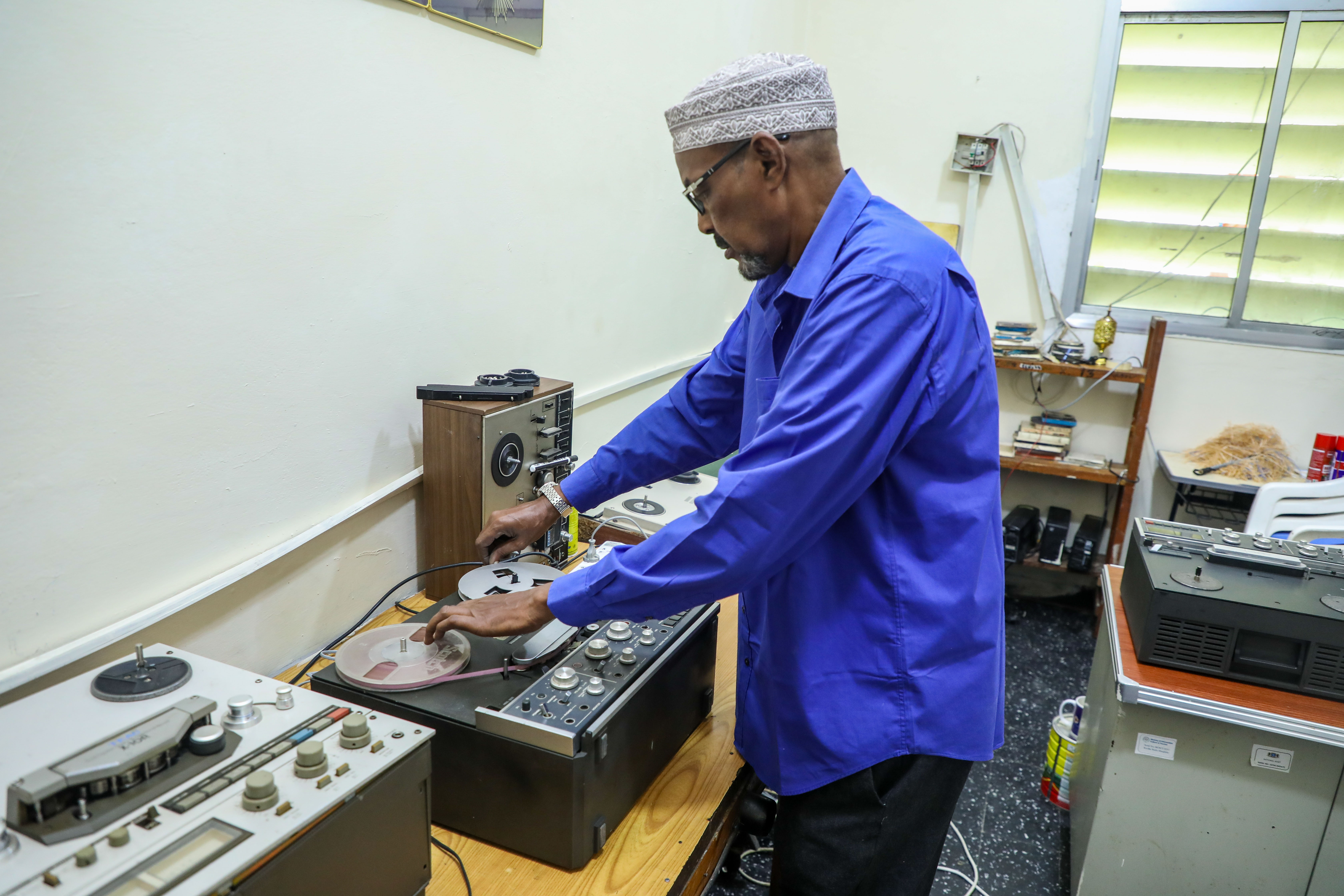 Abdiqadir Geedi Robleh cues up a tape, ready to hear a recording for the first time in years. [Abdimajid Abdillahi Farah/Al Jazeera]