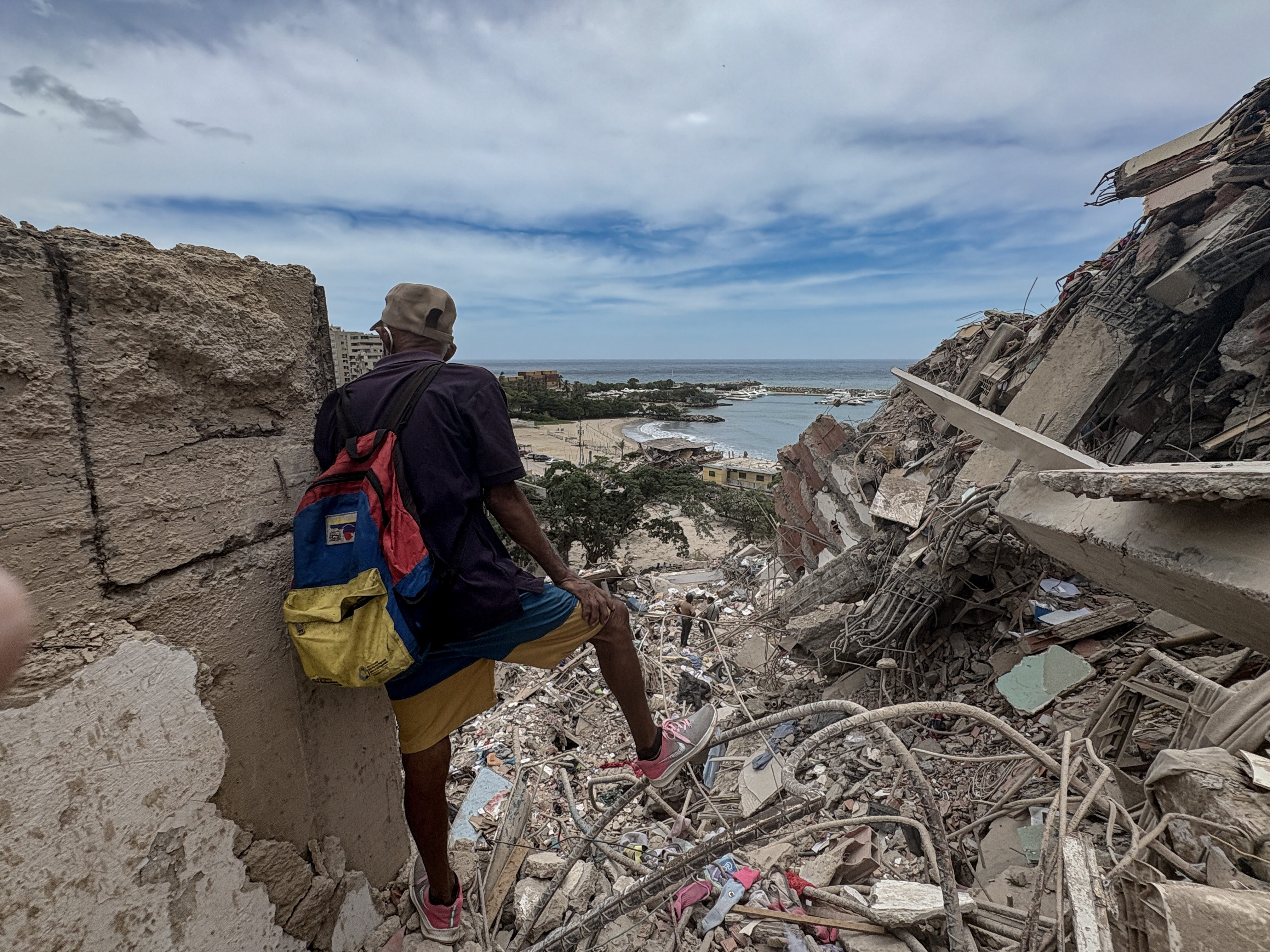 From the top of a destroyed building, a man surveys the destruction in the seaside city of Catia la Mar, Venezuela