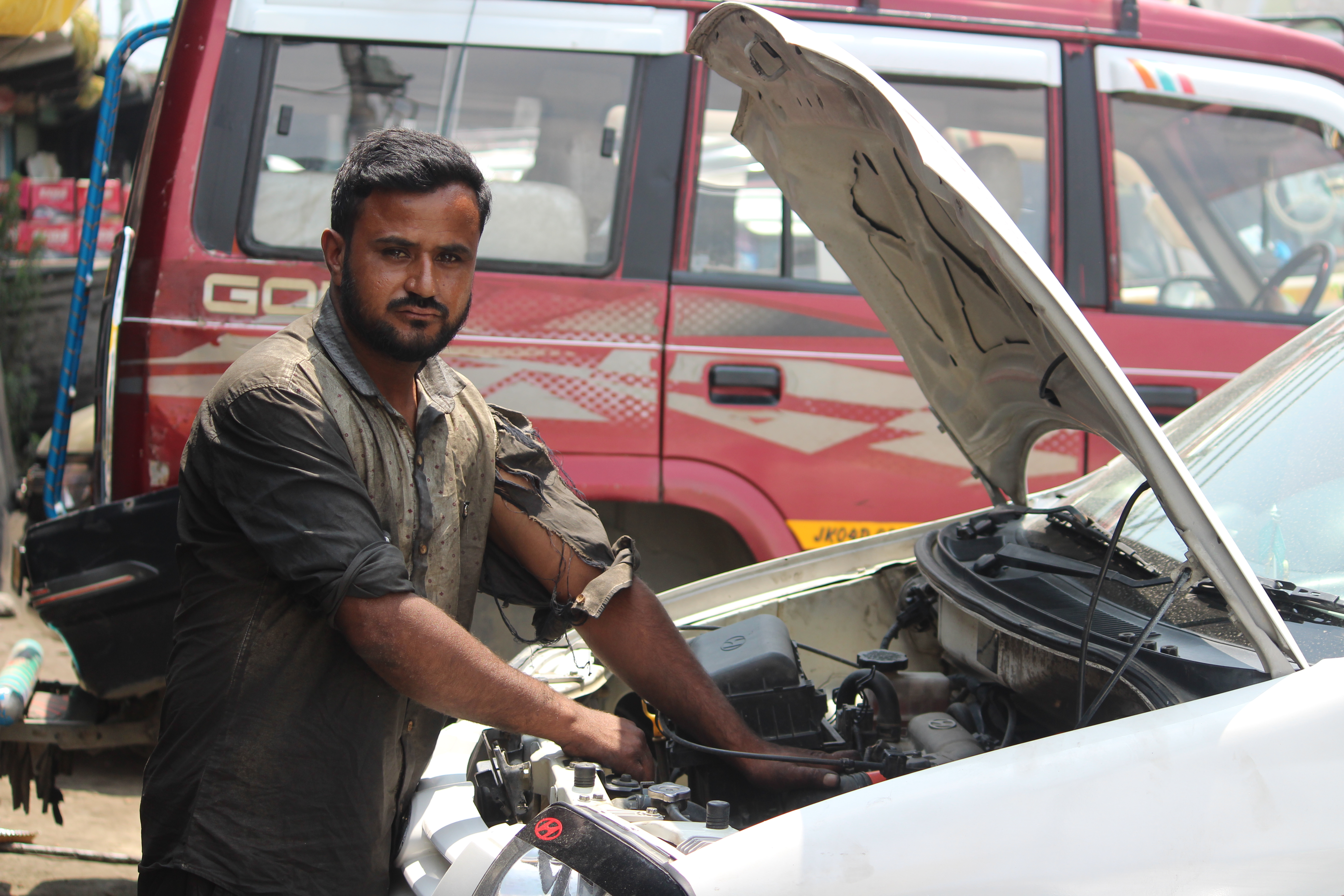 A mechanic repairs a car engine.