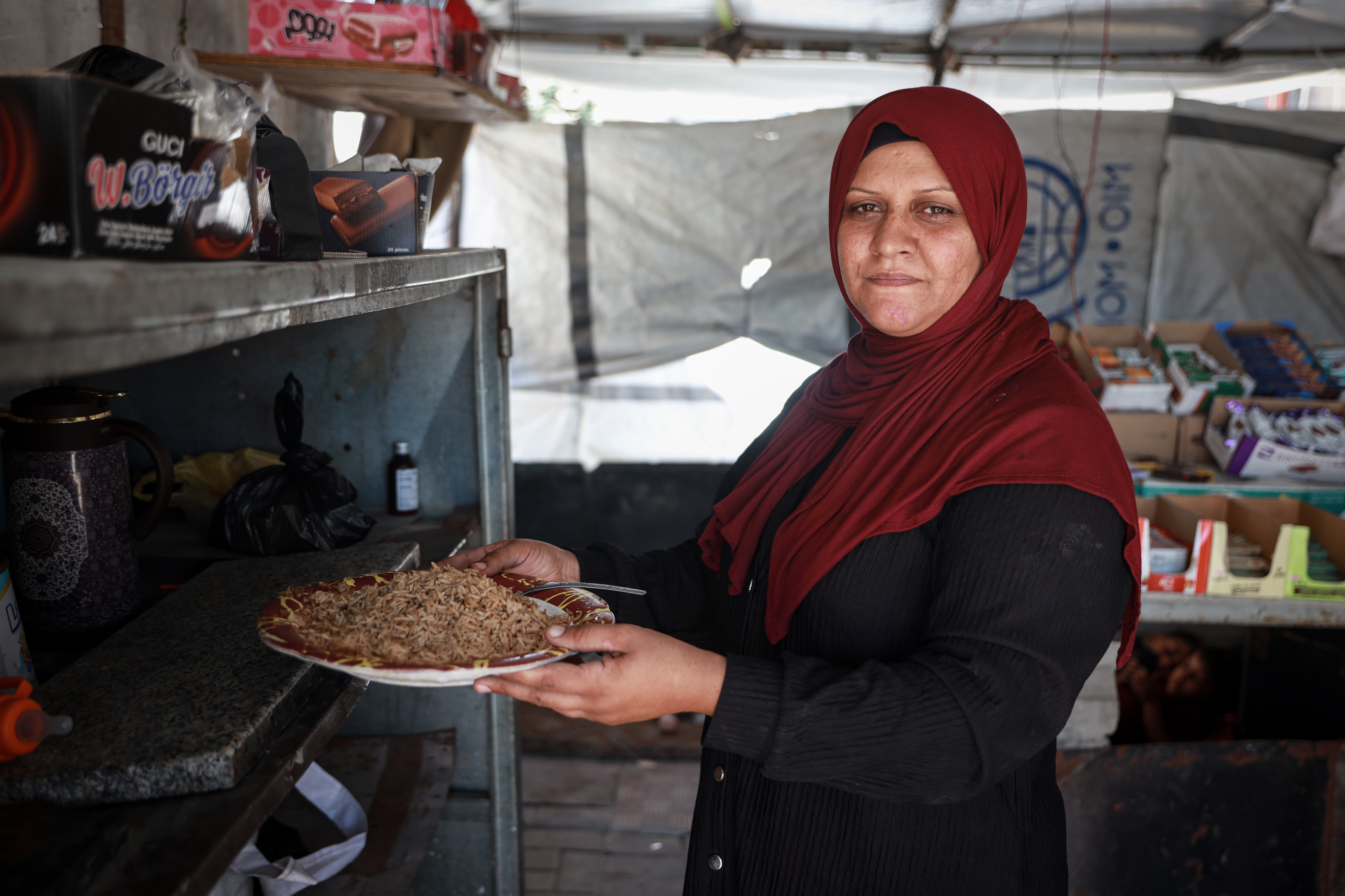 Malak Al-Zaanin struggles to store her family’s daily meal inside their tent due to the lack of electricity and refrigeration. [Abdelhakim Abu Riash/ Al Jazeera]