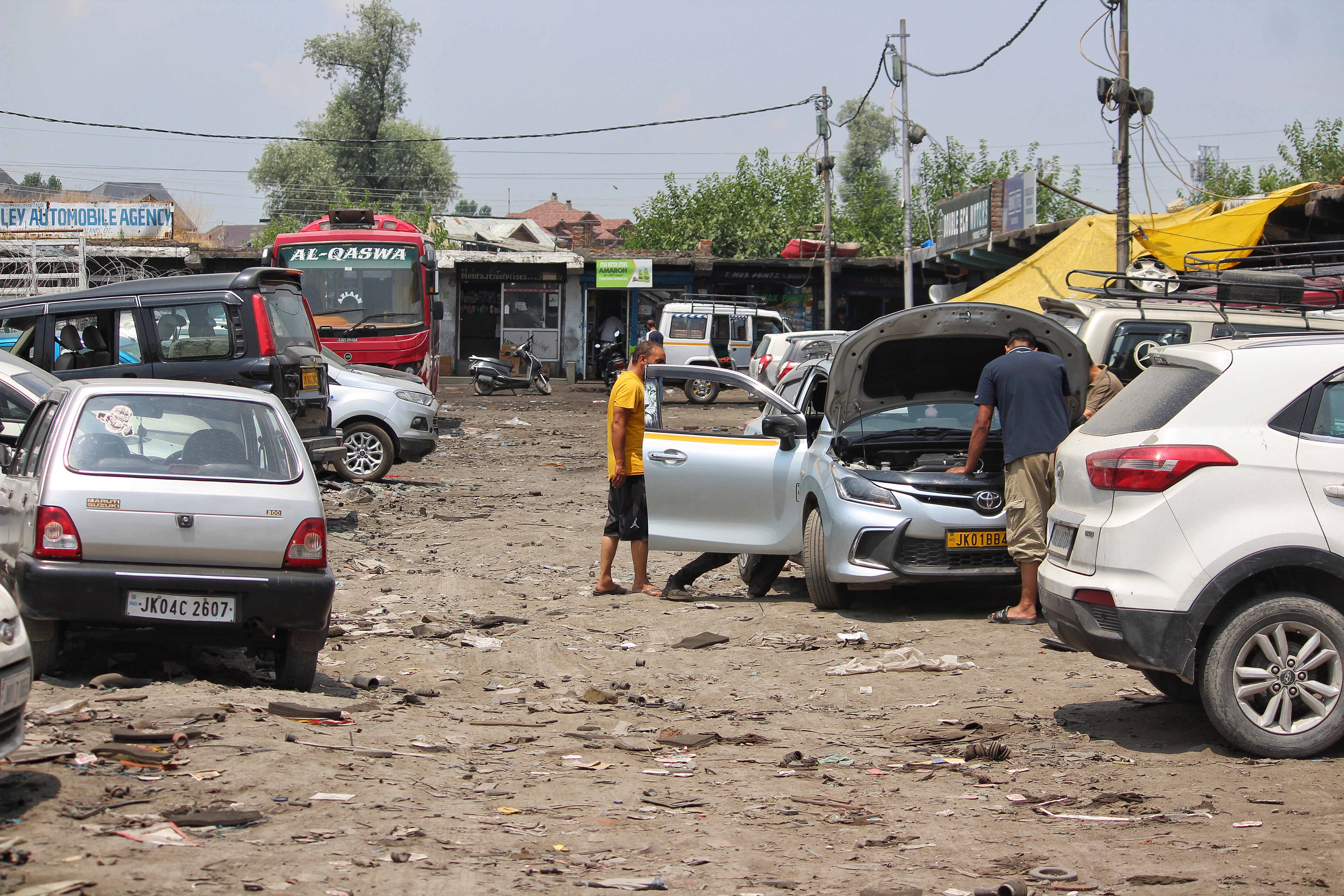 Vehicle owners inspect and repair cars at an automobile repair market in Srinagar as motorists seek advice on the compatibility of older vehicles with newly introduced E20 petrol.
