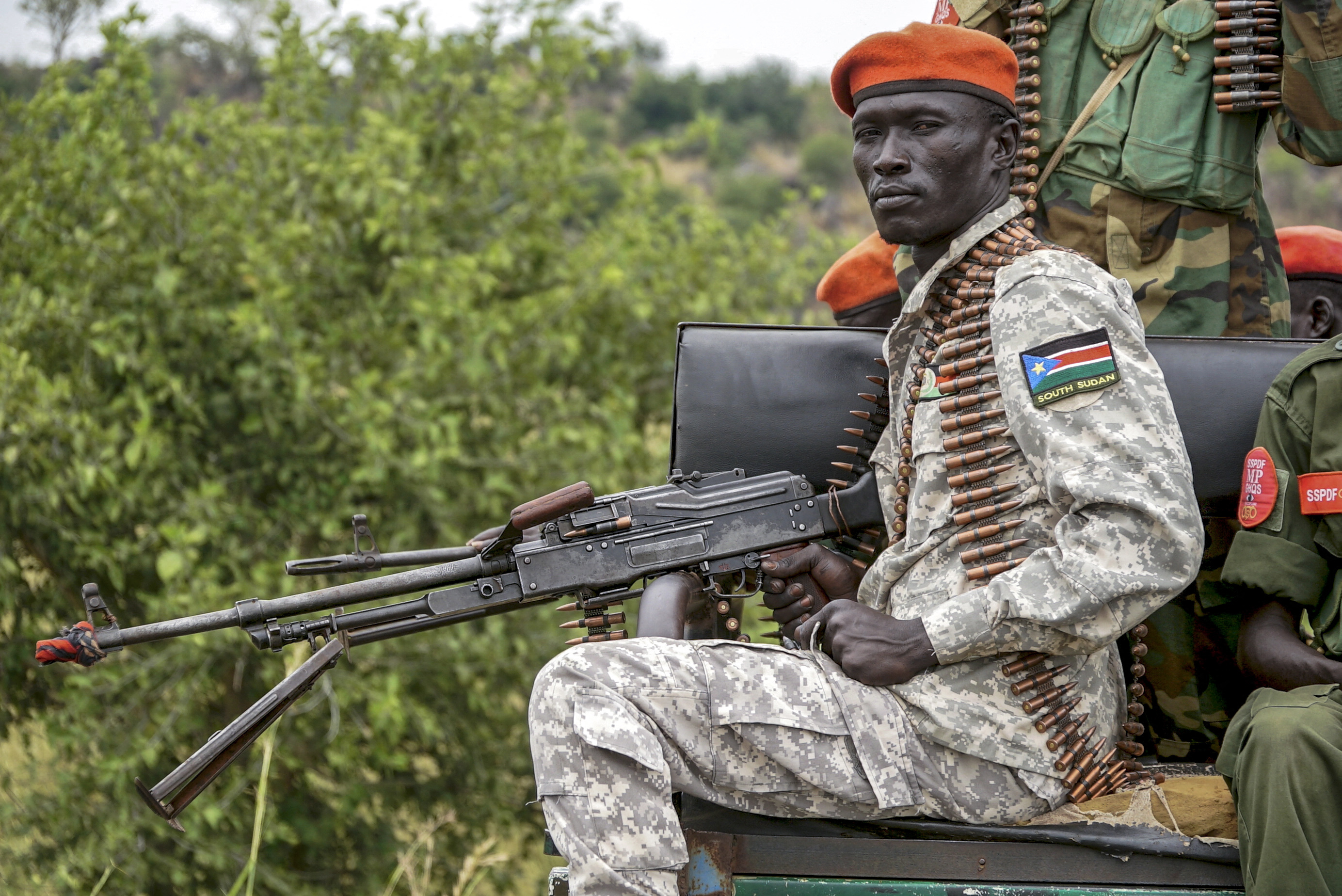 A South Sudanese military police officer sits on a pickup truck while monitoring the area as troops belonging to the South Sudanese Unified Forces take part in a deployment ceremony at the Luri Military Training Centre in Juba on November 15, 2023. Hundreds of former rebels and government troops in South Sudan's Unified Forces were deployed at a long-overdue ceremony on November 15, 2023, marking progress for the country's lumbering peace process. (Photo by Peter Louis GUME / AFP)