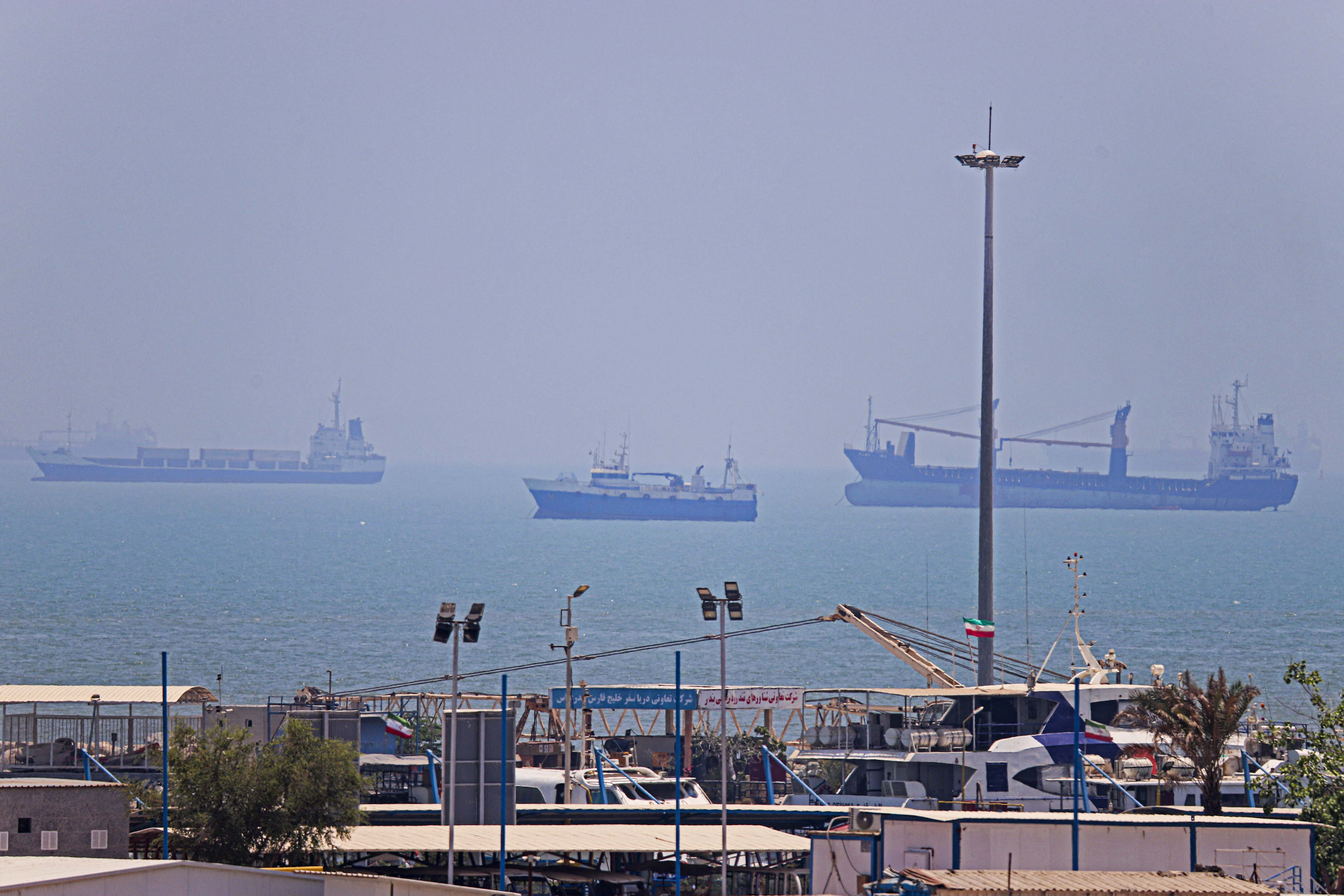 In this picture obtained from Iran's ISNA news agency on June 18, 2026, vessels are seen anchored in Bandar Abbas along the Strait of Hormuz. Oil prices tumbled after Trump and his Iranian counterpart separately signed their accord to end the Middle East war, with the Strait of Hormuz to reopen but two months of negotiations lying ahead. (Photo by AMIRHOSSEIN KHORGOOEI / ISNA / AFP) /