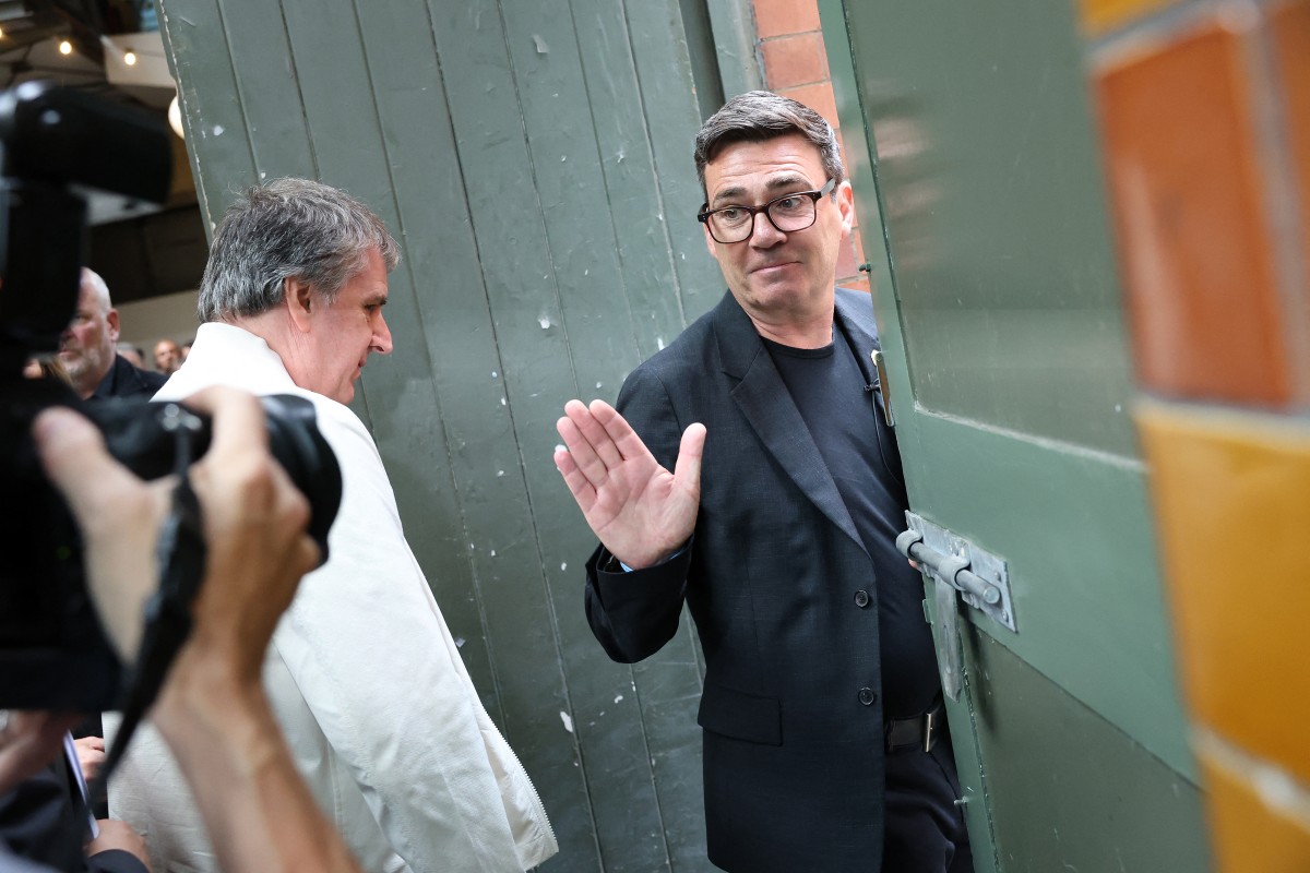 Andy Burnham waves as he leaves with the mayor of the Liverpool City Region, Steve Rotheram, after delivering a speech in Manchester, northern England, on June 29, 2026