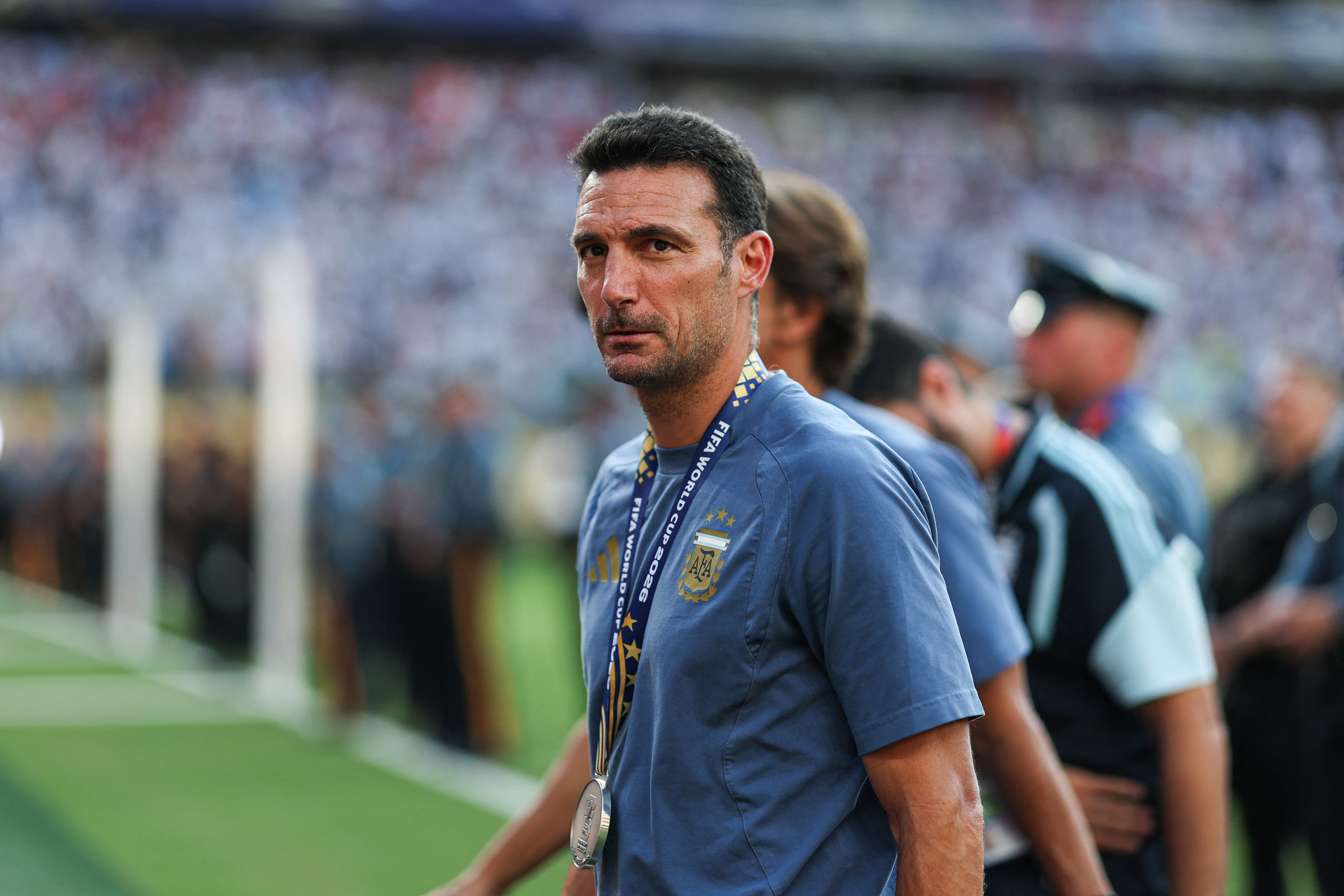 A man stands on a pitch in a stadium