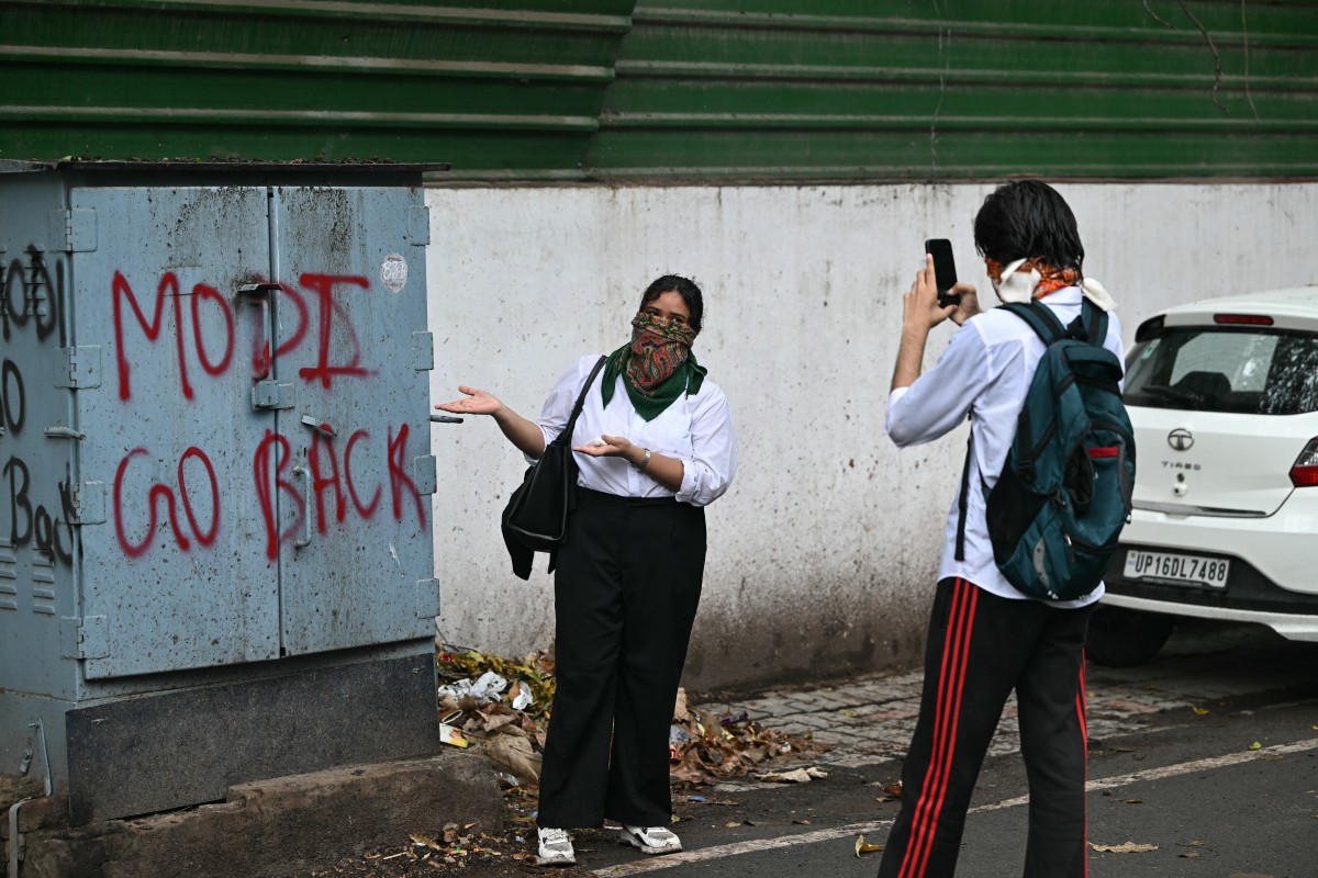 A CJP supporter poses next to a protest message in New Delhi after the police crackdown on July 20, 2026