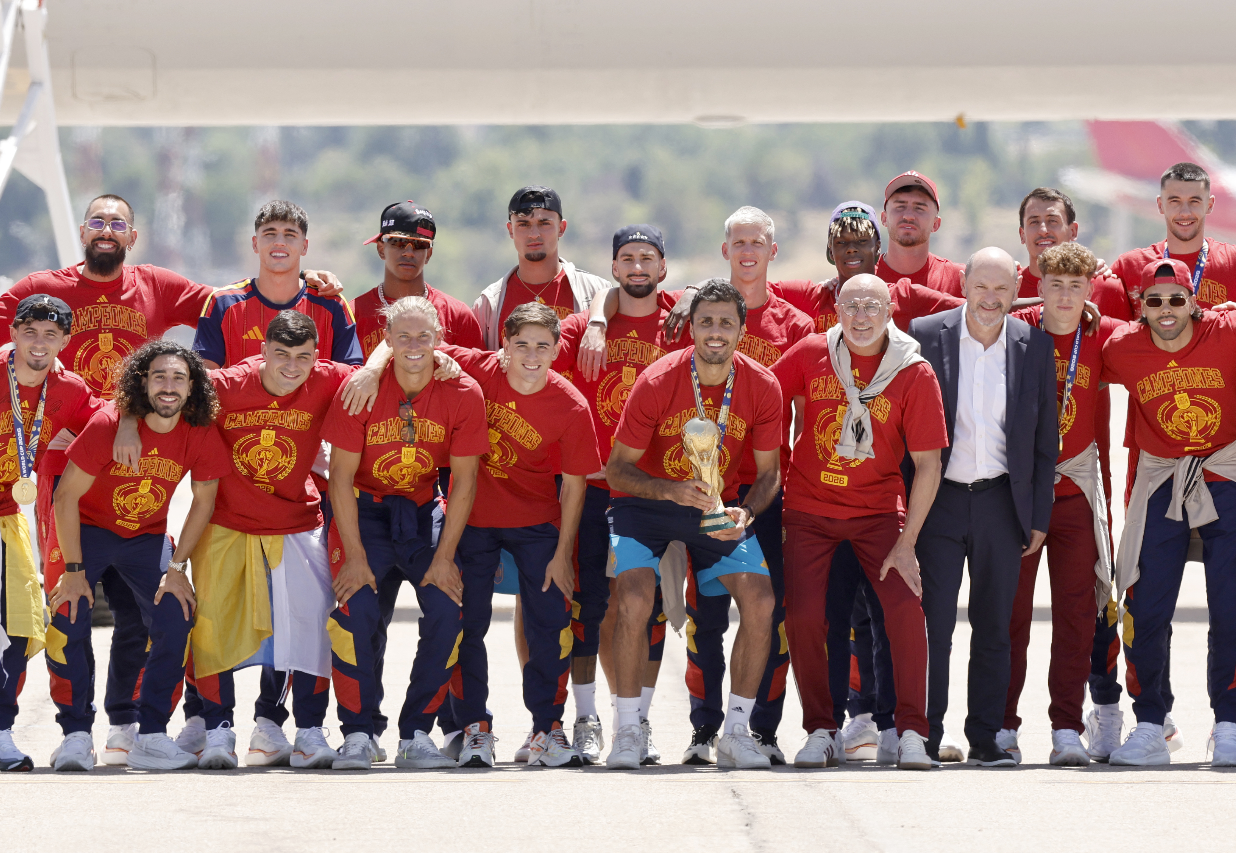Spain's team pose with their trophy on the tarmac upon their arrival from the US after winning the 2026 World Cup, in Madrid Barajas' airport, on July 20, 2026. Spain's World Cup winners come back home to a heroes' welcome in Madrid, where a million fans are expected to greet them after a night of raucous celebrations across the country. (Photo by Oscar DEL POZO / AFP)