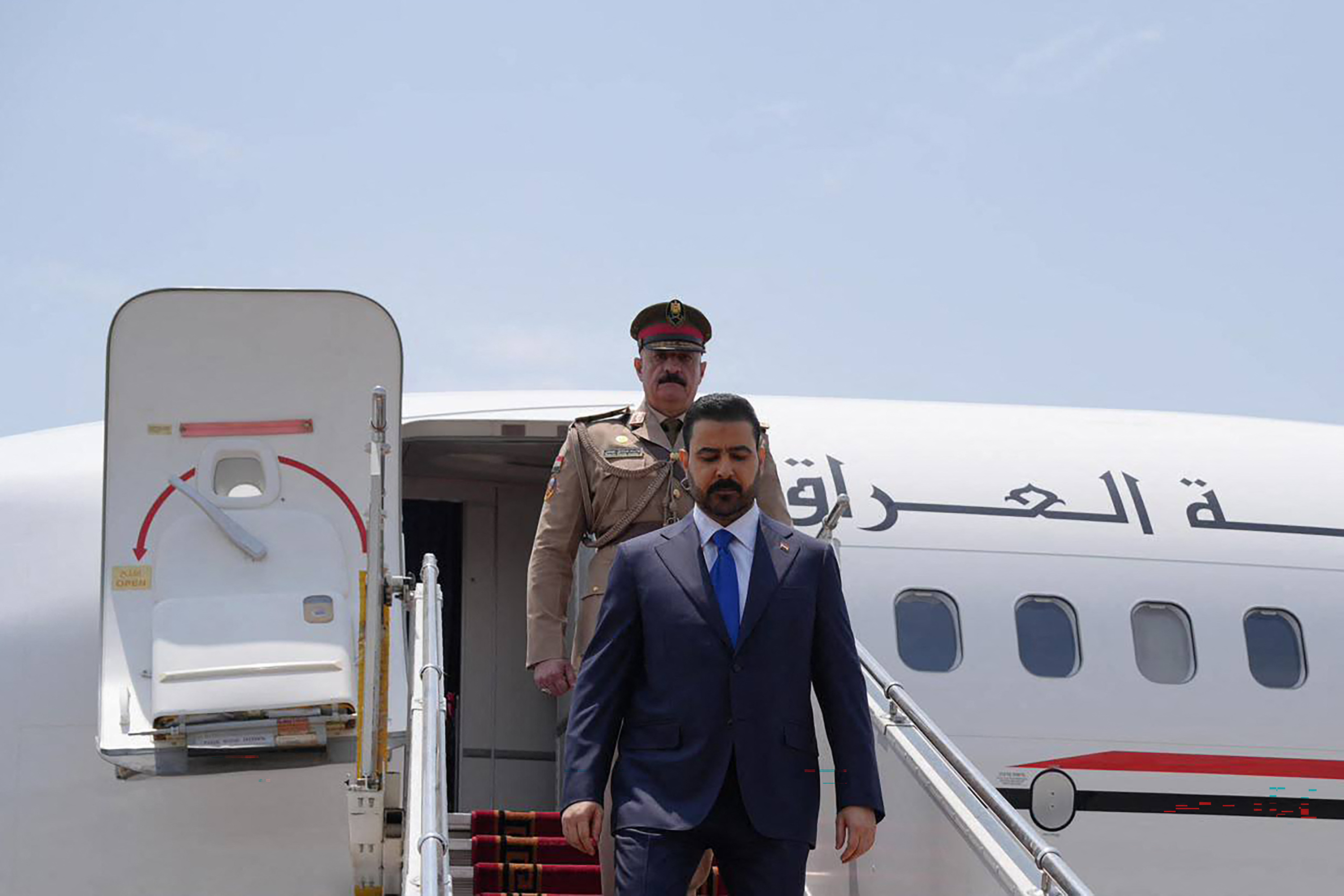 This handout picture taken and released on July 23, 2026 by the Iraqi Prime Minister's Office shows Iraq's Prime Minister Ali al-Zaidi (R) disembarking from his plane upon landing in Tehran. (Photo by IRAQI PRIME MINISTER'S PRESS OFFICE / AFP) / RESTRICTED TO EDITORIAL USE - MANDATORY CREDIT "AFP PHOTO / IRAQI PRIME MINISTER'S OFFICE / HANDOUT / " - NO MARKETING NO ADVERTISING CAMPAIGNS - DISTRIBUTED AS A SERVICE TO CLIENTS