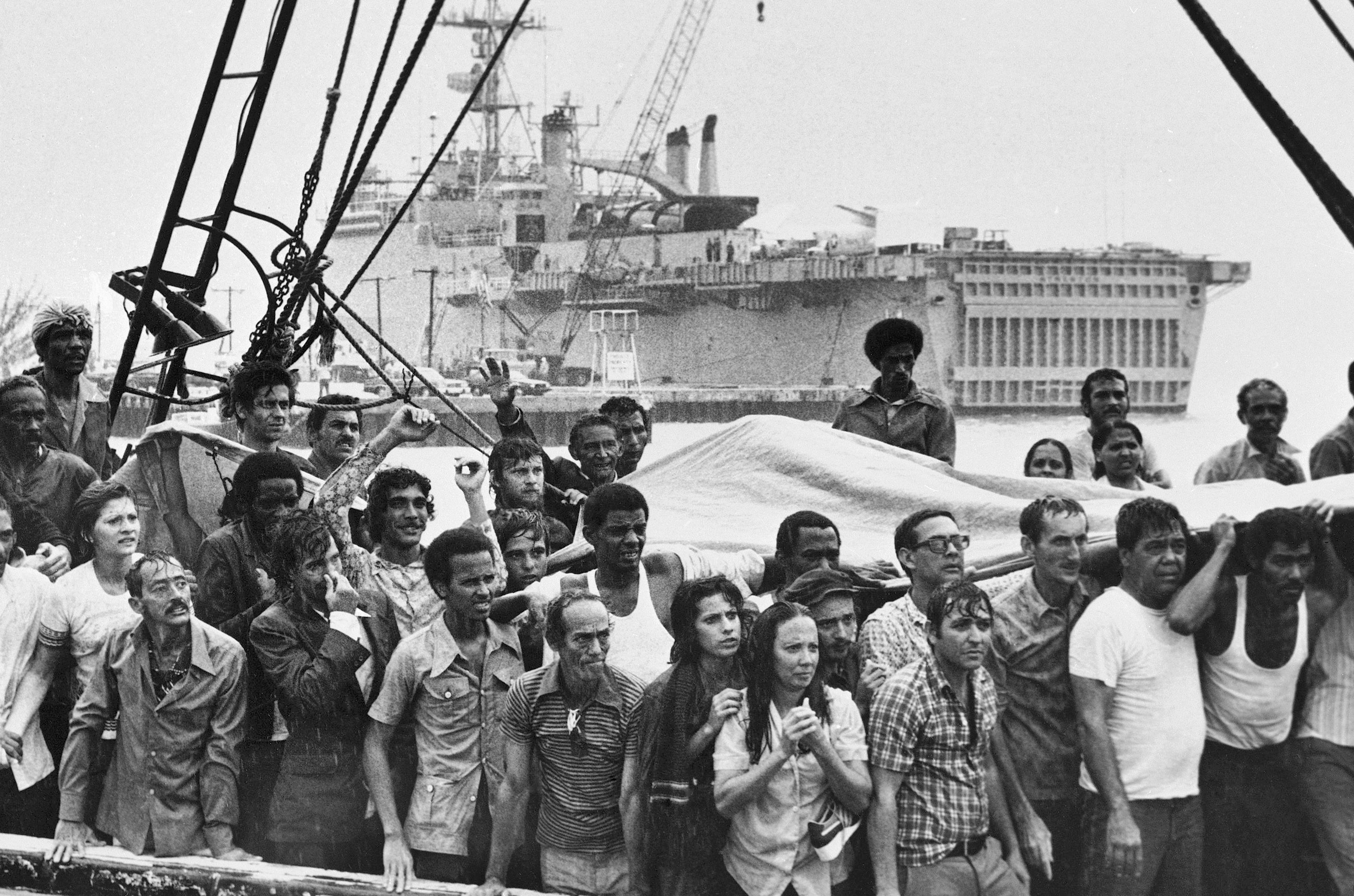 FILE - In this May 1980 file photo, refugees from Cuba stand on the deck of their boat as they arrive at a rainy Key West, Fla. In the Mariel Boatlift, more than 100,000 Cubans fled the island by sea in the space of just six months. (AP Photo/Eddie Adams)