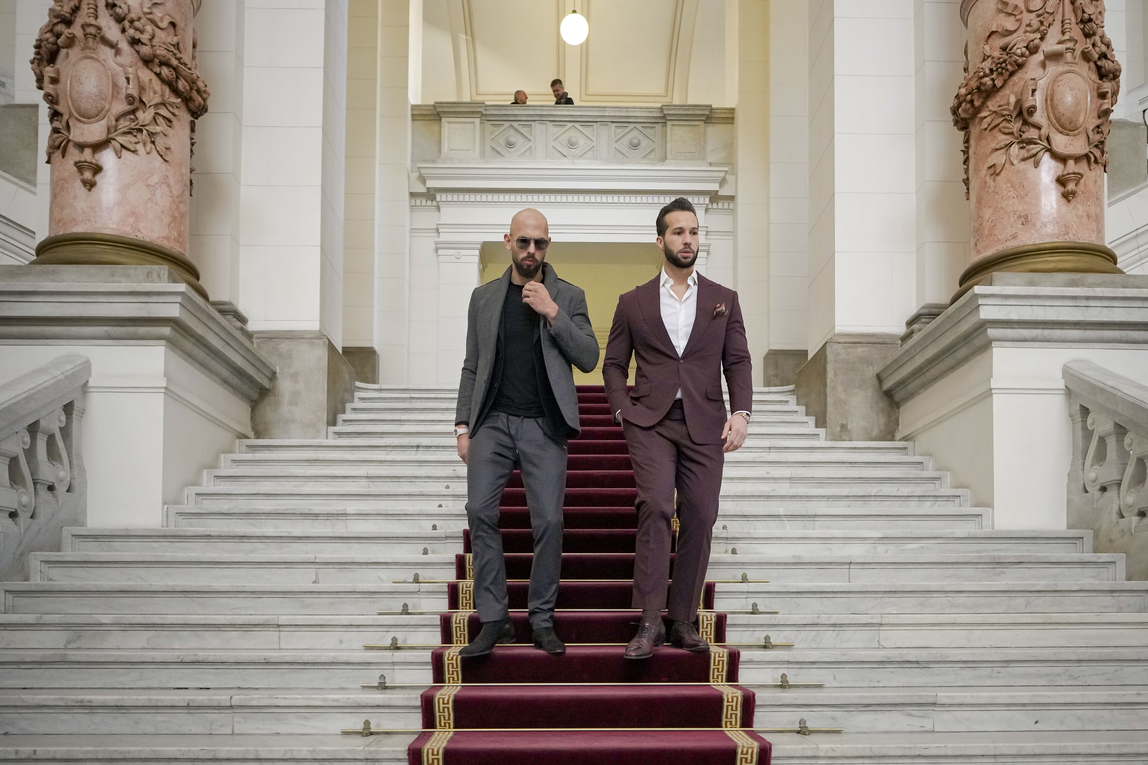 Andrew and Tristan Tate walk down the stairs of the Bucharest Court of Appeal in Romania