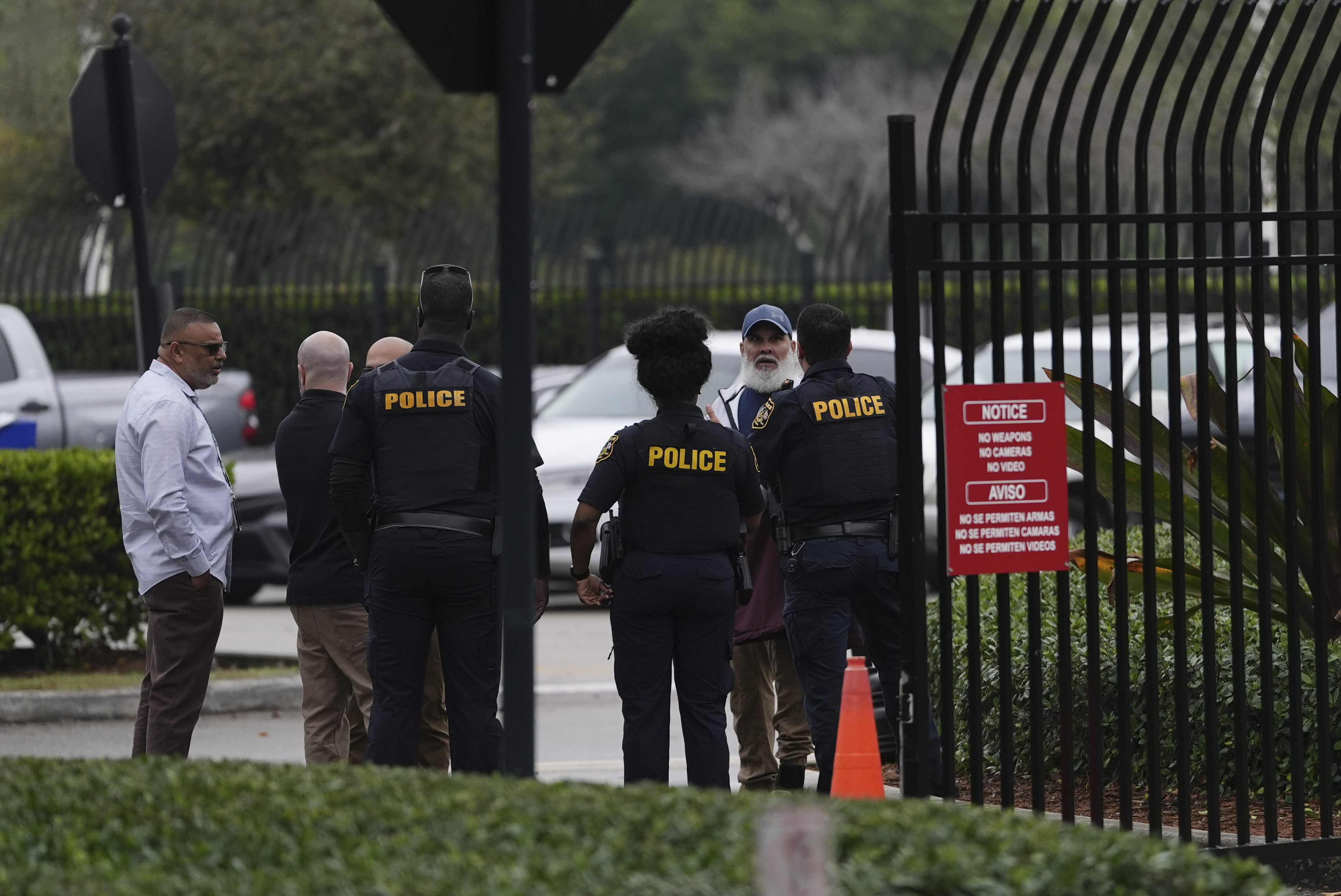 Cuban migrant Wilfredo Cabrera Del Sol, second right, implores immigration officials and local police, who he called, to detain and deport him, at the U.S. Immigration and Customs Enforcement office in Miramar, Fla., Tuesday, Jan. 21, 2025. In contrast to the other migrants there for appointments to establish or maintain their status in the U.S., Cabrera was asking to be sent home, pointing to an ICE Order of Supervision issued after he served a three-year sentence on a felony drug charge. Cuba often refuses deportation flights from the U.S. (AP Photo/Rebecca Blackwell)