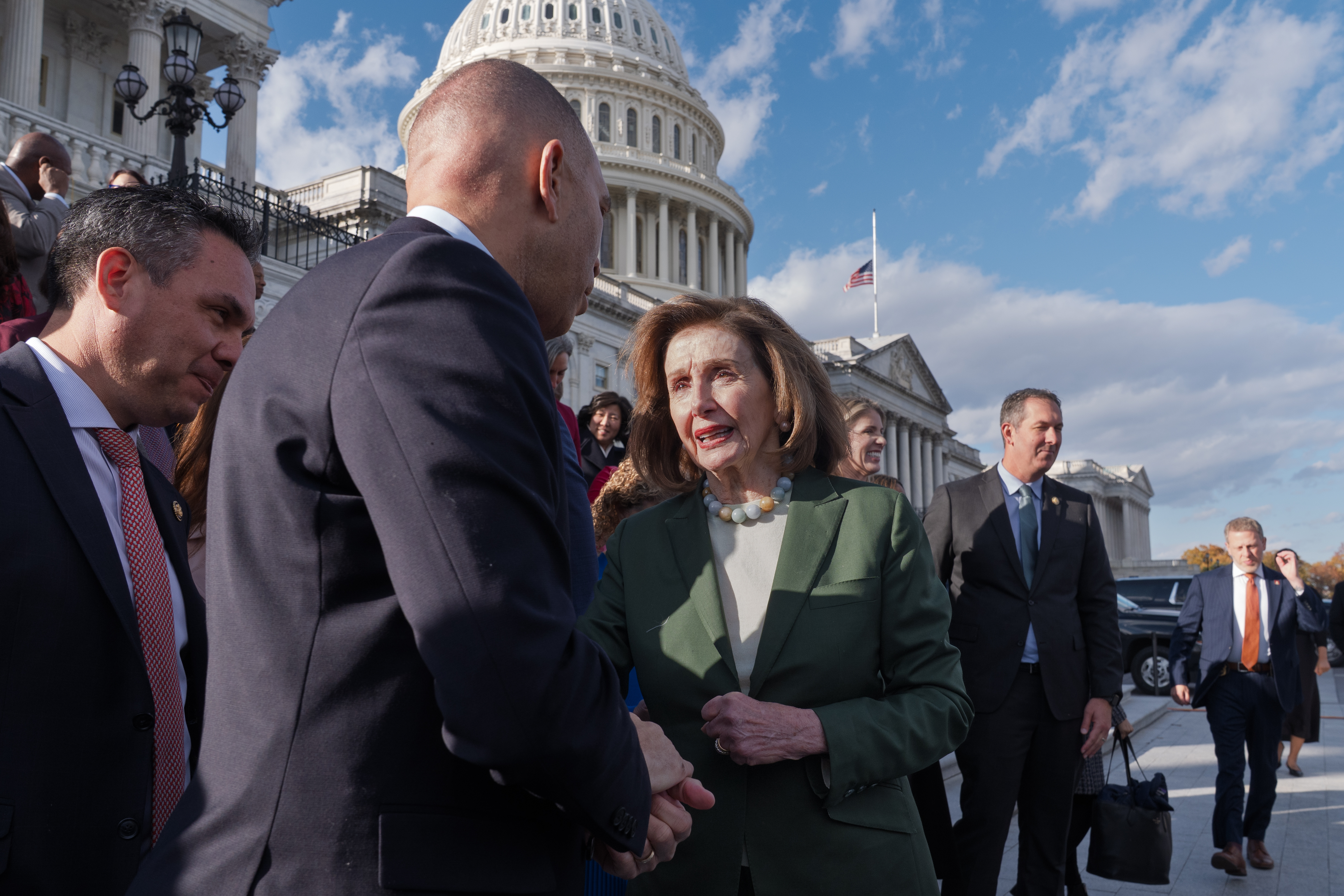 House Minority Leader Hakeem Jeffries, D-N.Y., left, embraces Speaker Emerita Nancy Pelosi, D-Calif., center, after praising her leadership on health care, during an event with fellow Democrats on the House steps before votes to end the government shutdown, at the Capitol in Washington, Wednesday, Nov. 12, 2025. (AP Photo/J. Scott Applewhite)