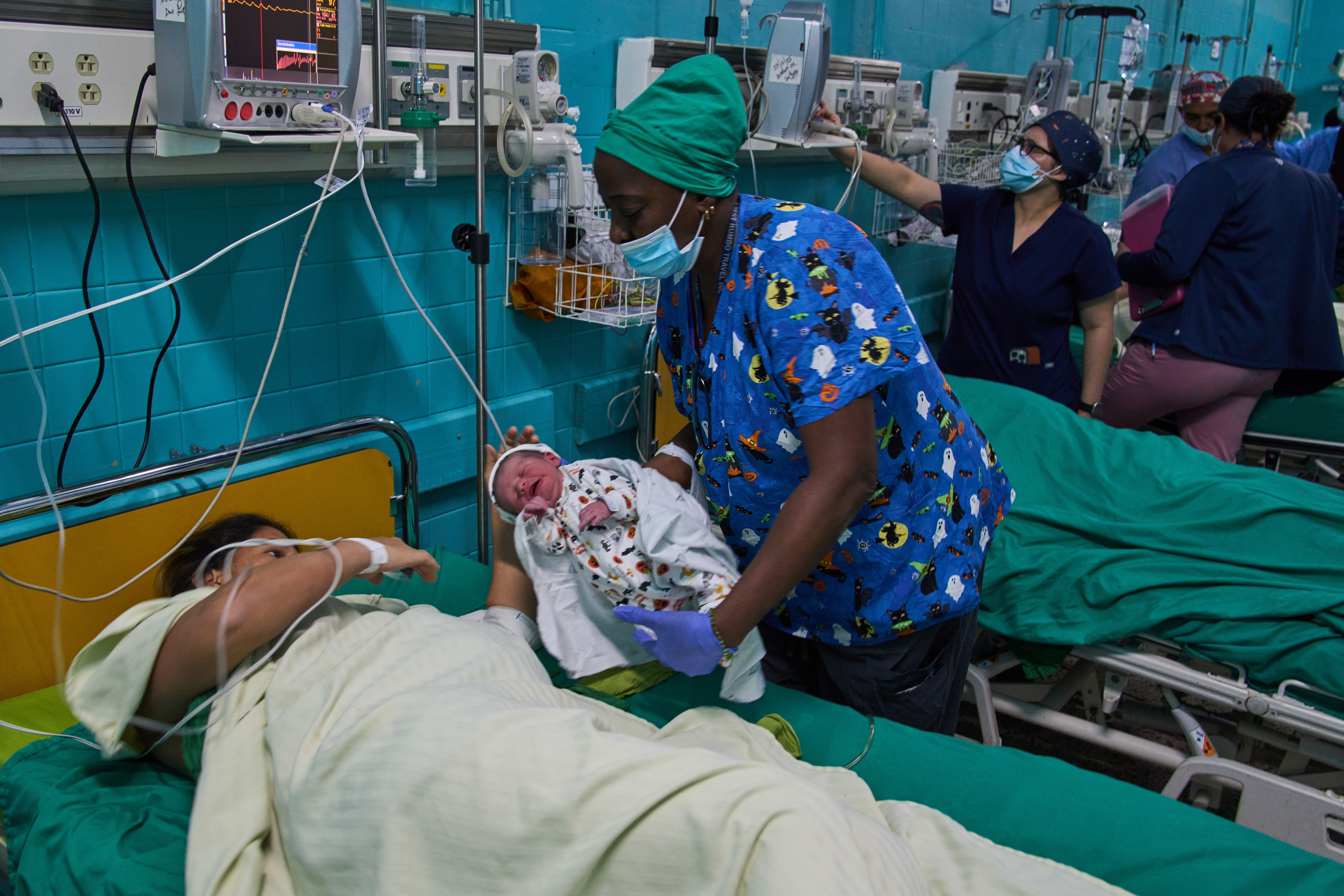 A doctor hands a newborn baby to its mother at the Ramón González Coro Maternity Hospital in Havana, Cuba, Friday, Feb. 20, 2026. (AP Photo/Ramon Espinosa)