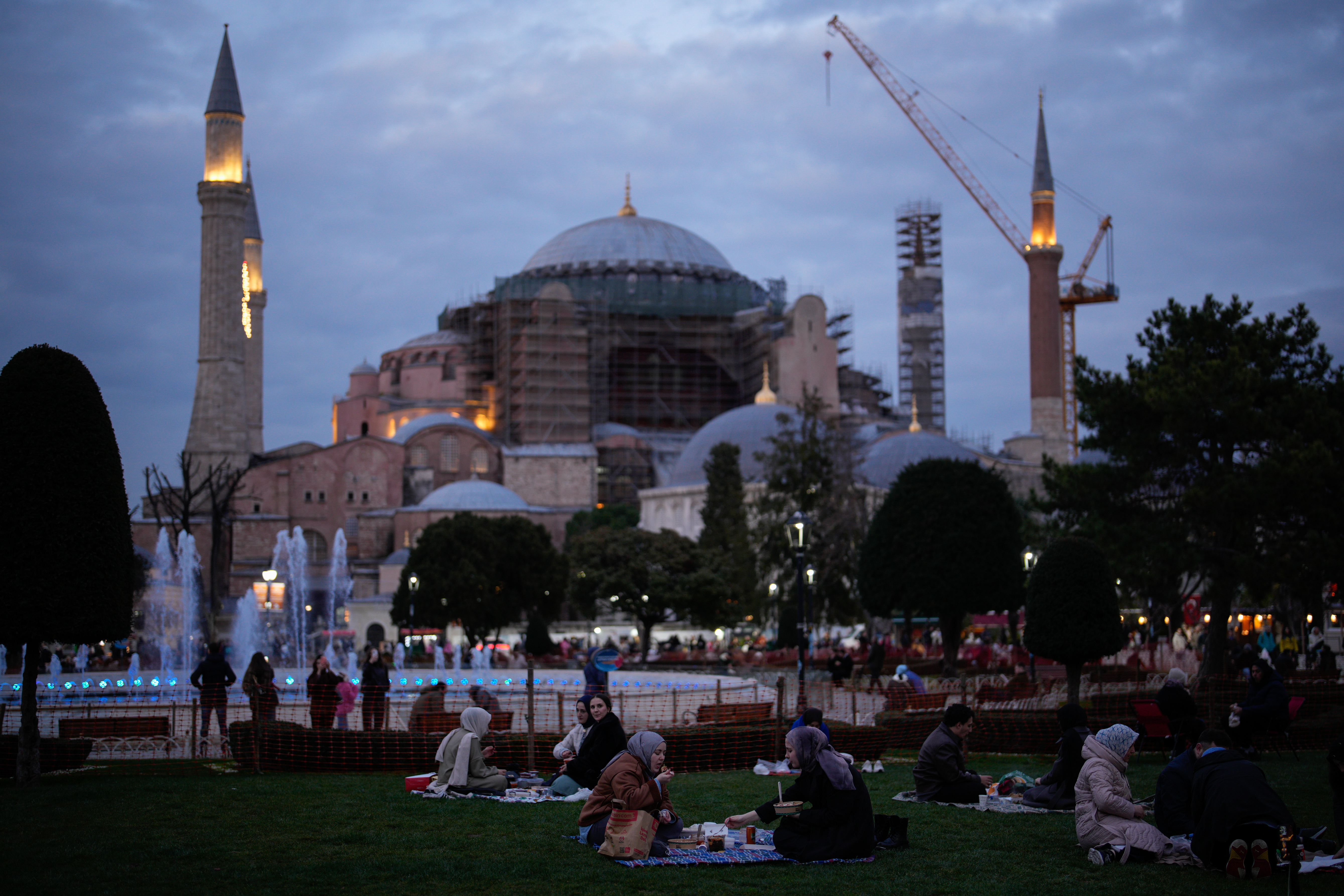 People break their fast after dusk during the Muslim holy fasting month of Ramadan, outside the iconic Byzantine-era Hagia Sophia mosque, in Istanbul, Turkey, Wednesday, Feb. 25, 2026.(AP Photo/Emrah Gurel)