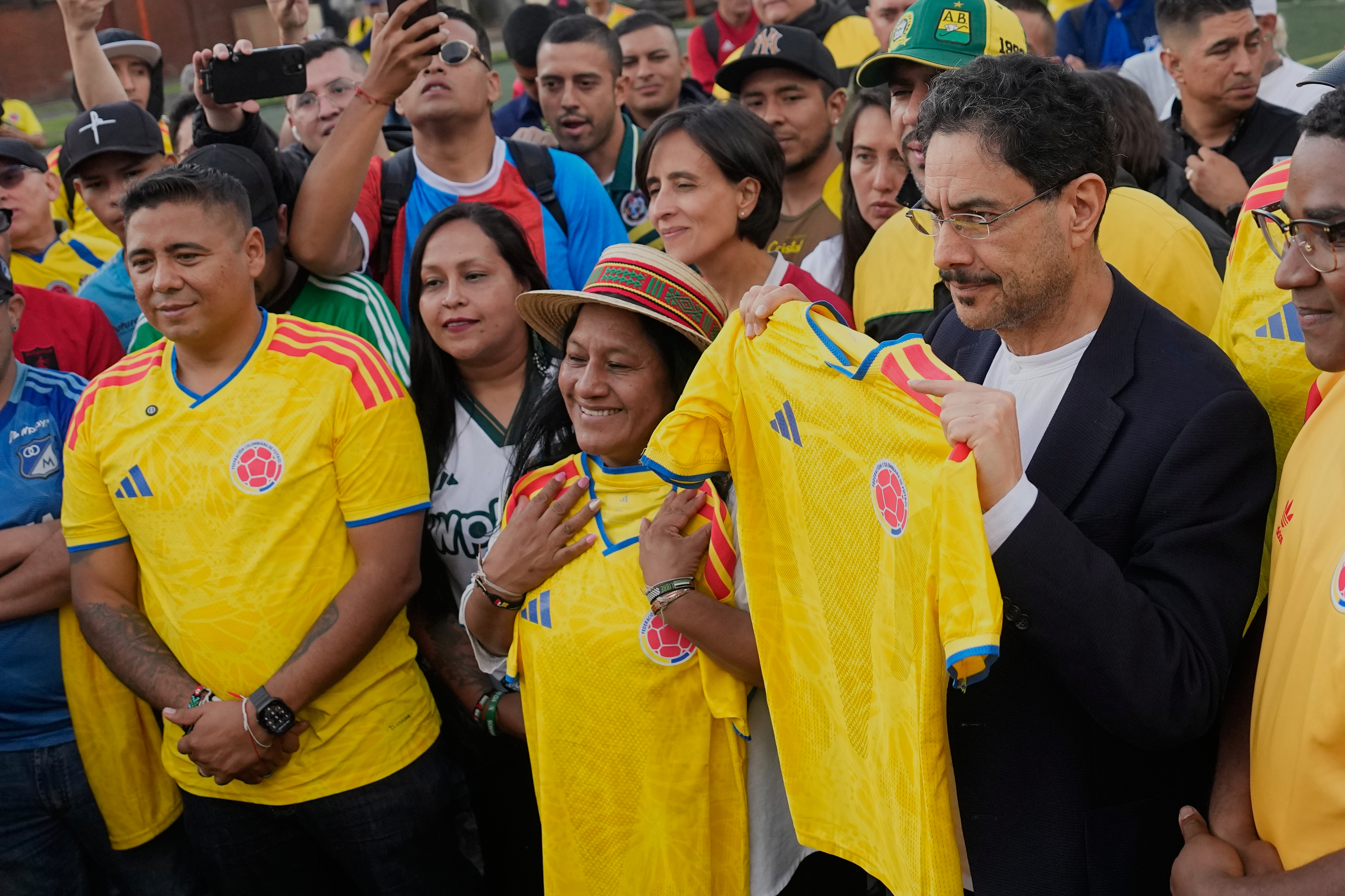 Presidential candidate Ivan Cepeda, of the ruling Historic Pact coalition, right, and his running mate, Sen. Aida Quilcue, center, hold up Colombian national soccer team jerseys during a campaign rally in Bogota, Colombia, Thursday, June 4, 2026. (AP Photo/Fernando Vergara)