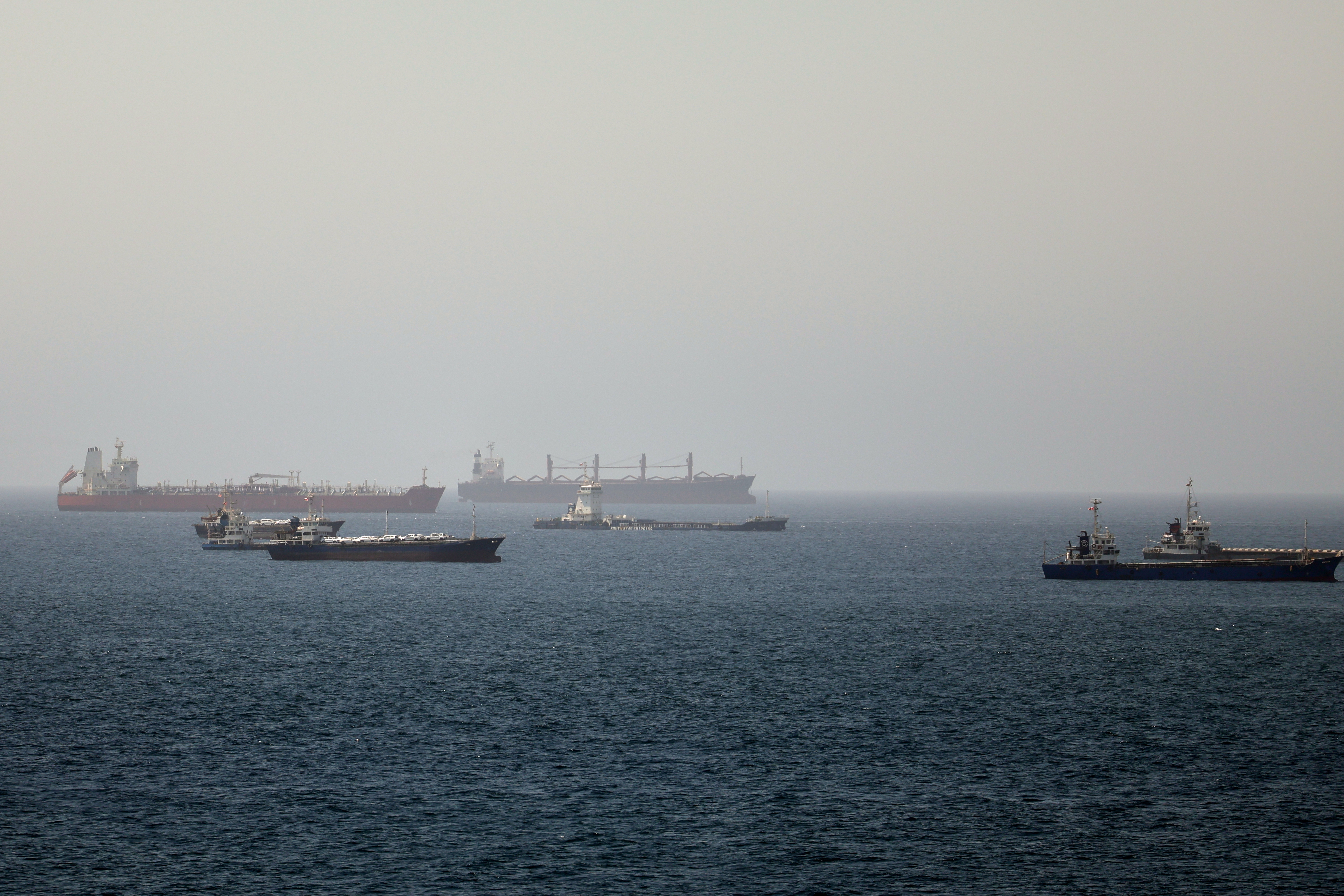 Tankers and cargo vessels are seen at sea.
