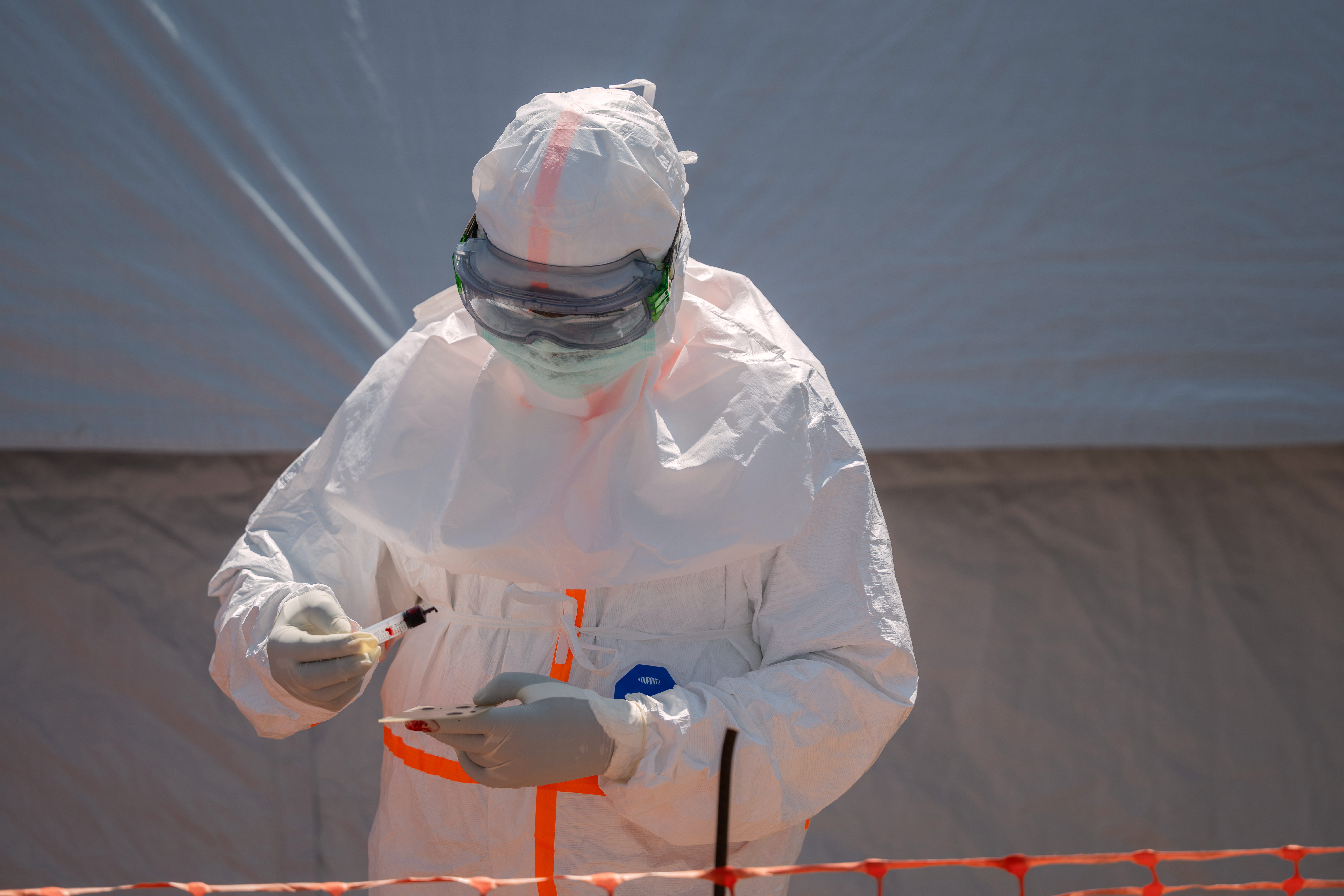 A health worker prepares a blood sample for testing.