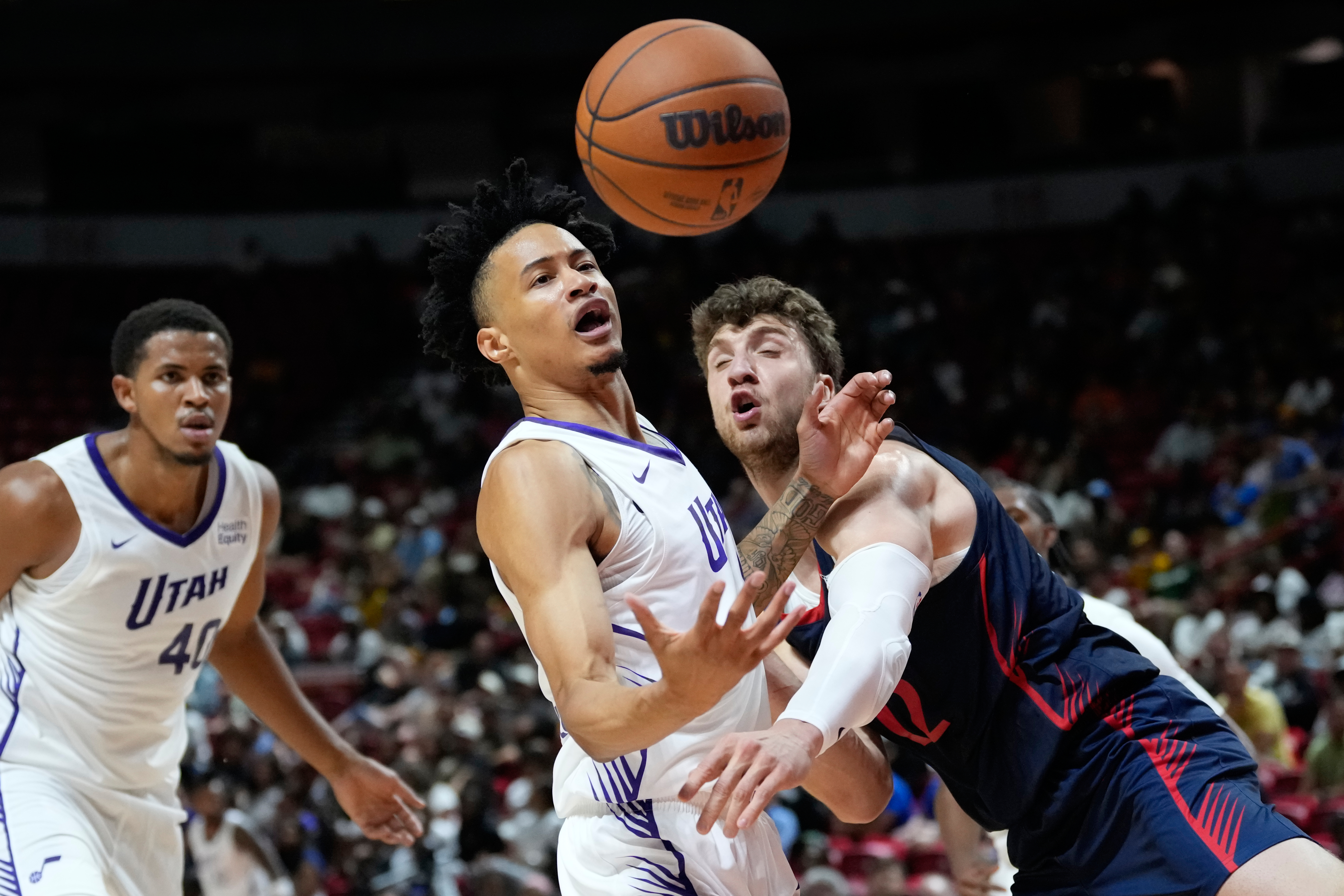 LA Clippers' Nick Martinelli, right, and Utah Jazz's Trey Alexander battle for a rebound during the first half of an NBA Summer League basketball