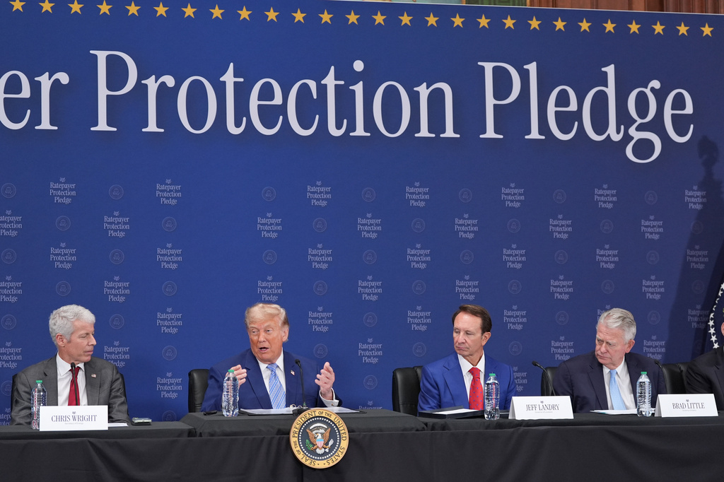 Trump sits at alongside officials at an event announcing ratepayer protections