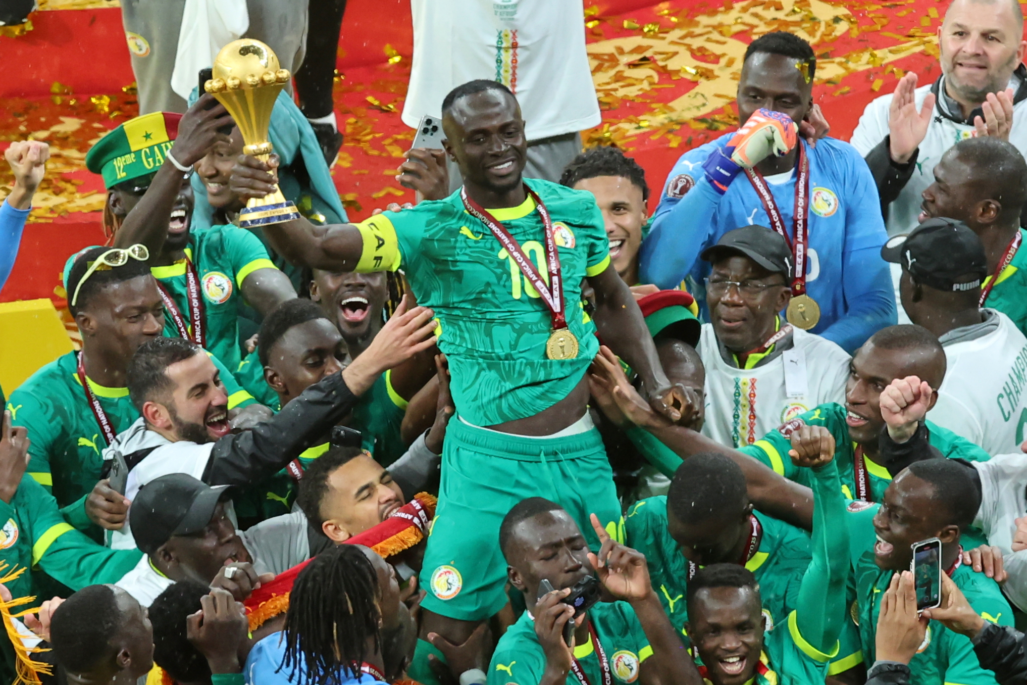Senegal's Sadio Mane holds the trophy aloft as he celebrates with teammates after winning the Africa Cup of Nations final