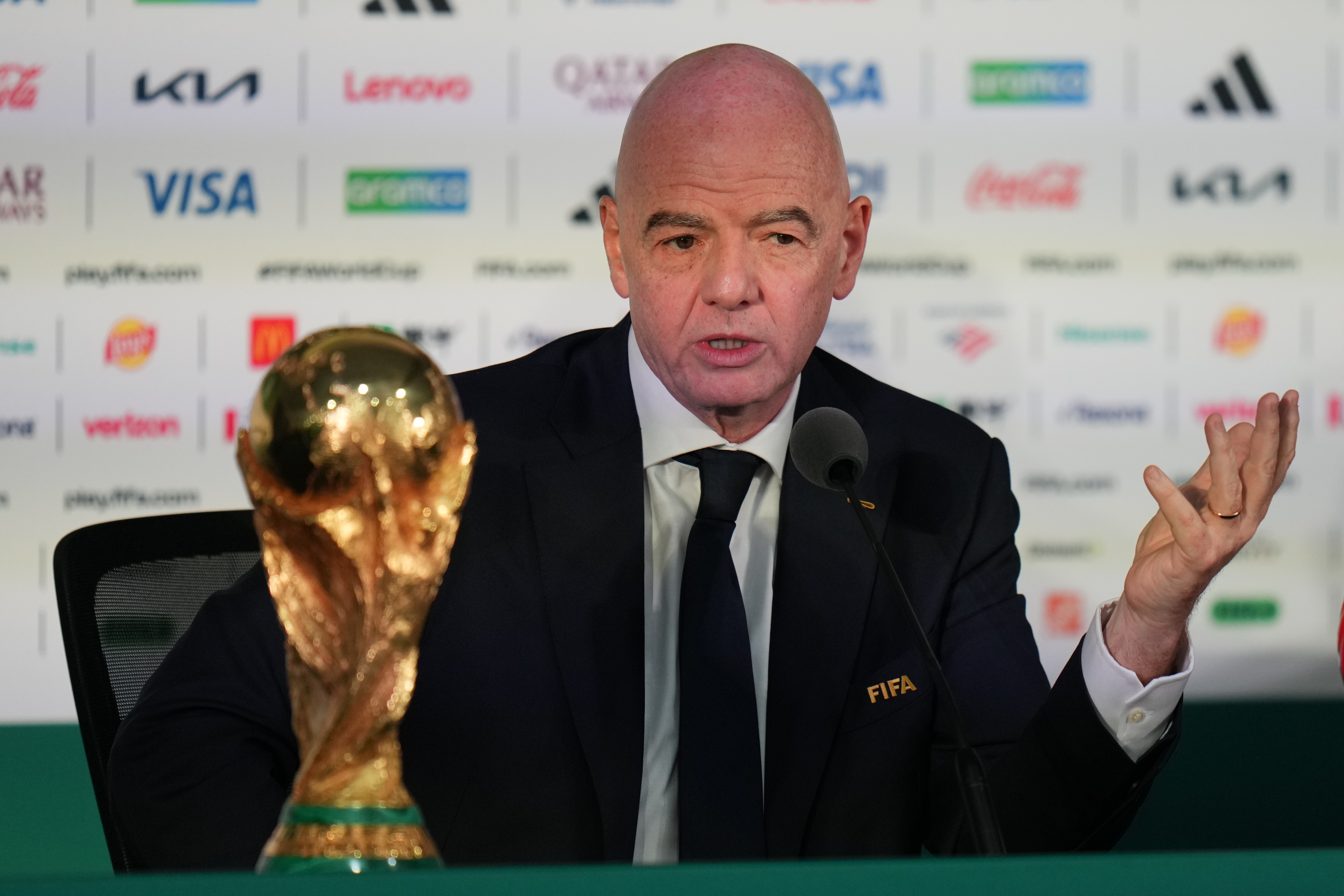 FIFA President Gianni Infantino speaks with the golden World Cup next to him.