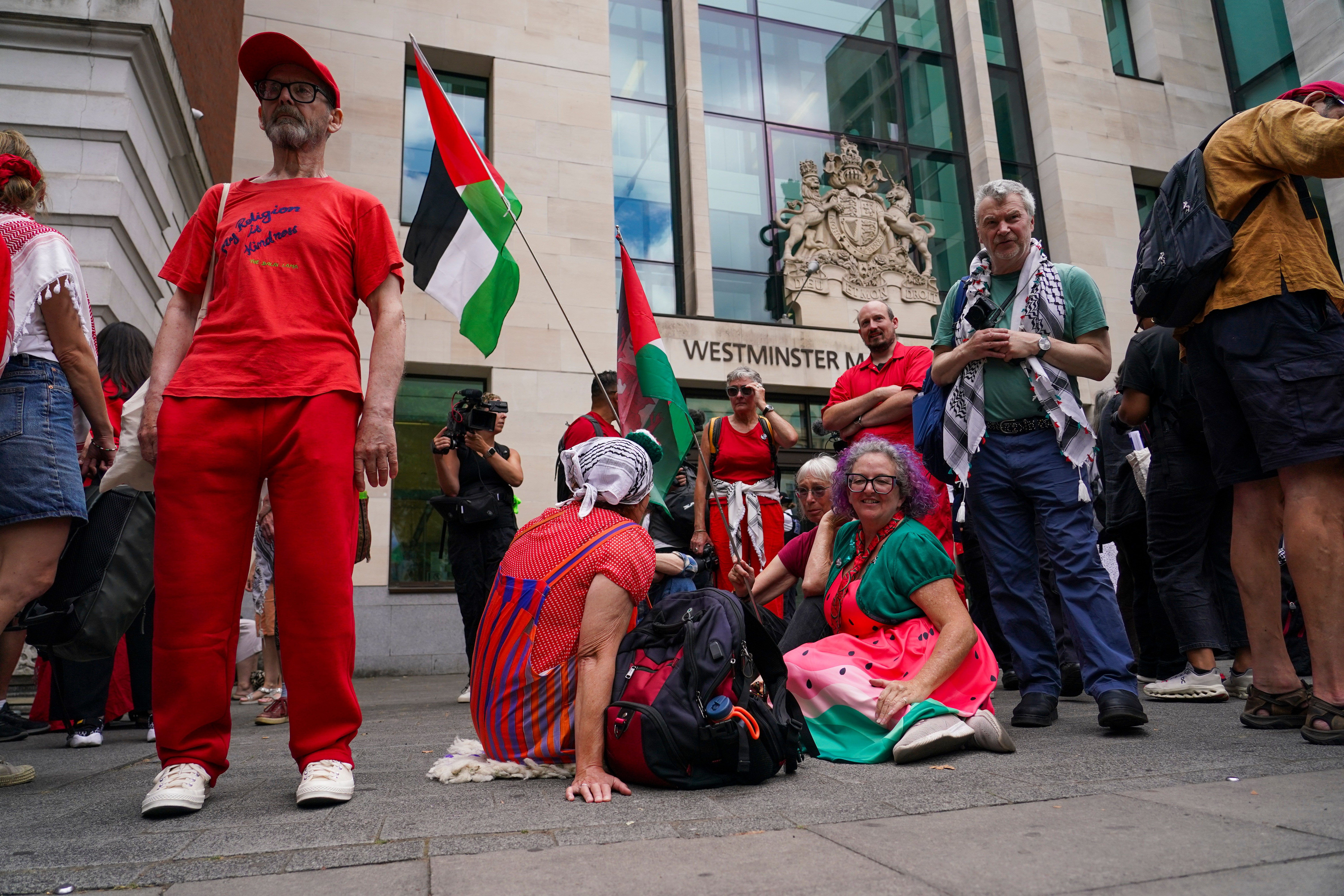 Demonstrators sit outside Westminster Magistrates’ Court in London as a plea hearing for 25 people accused of showing support for Palestine Action takes place, on July 30, 2026