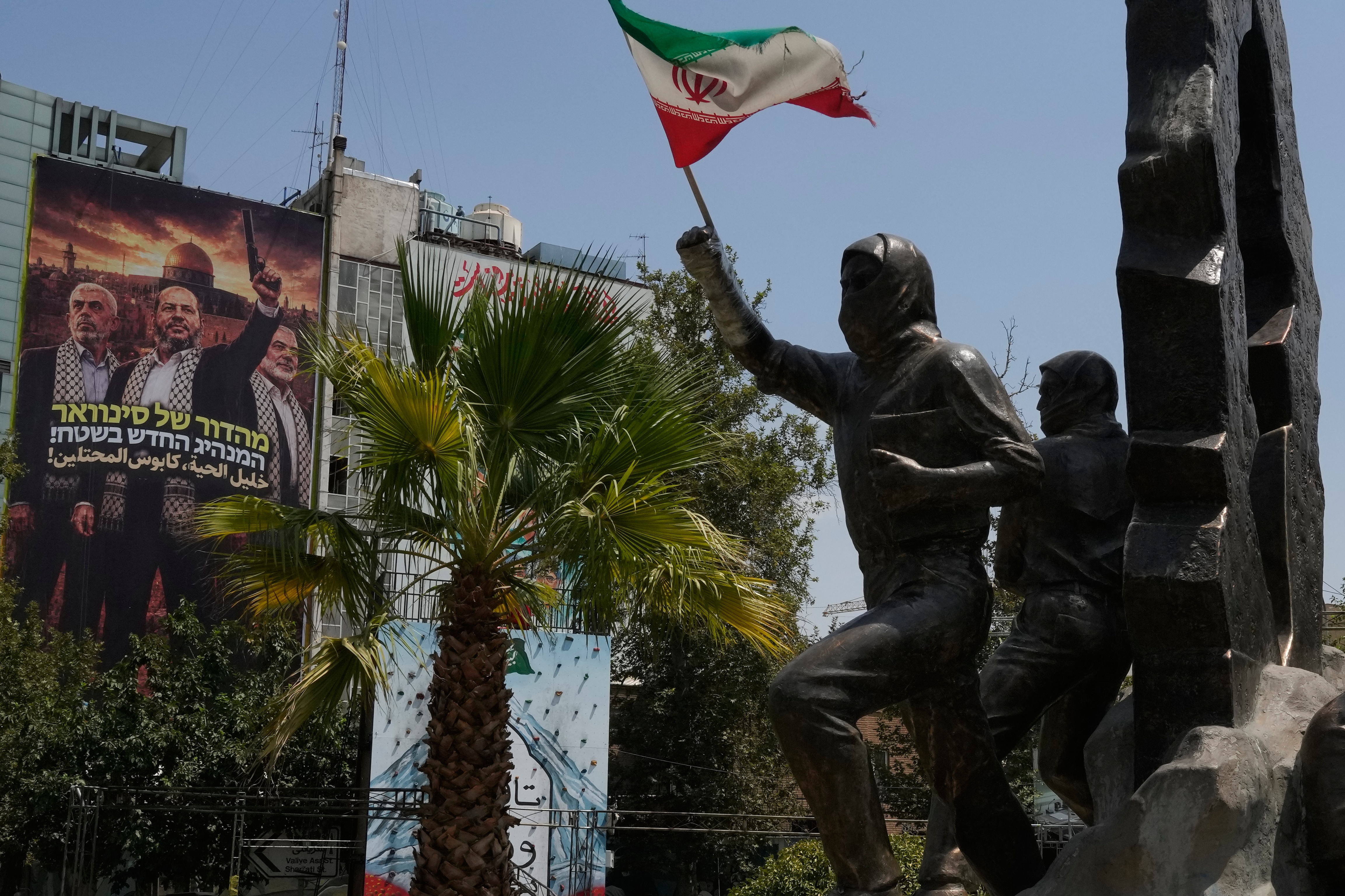 A statue of Palestinians stands with Iranian flag as a banner shows Hamas leaders at the Palestine square in downtown Tehran, Iran, August 1, 2026. [Vahid Salemi/APPhoto]