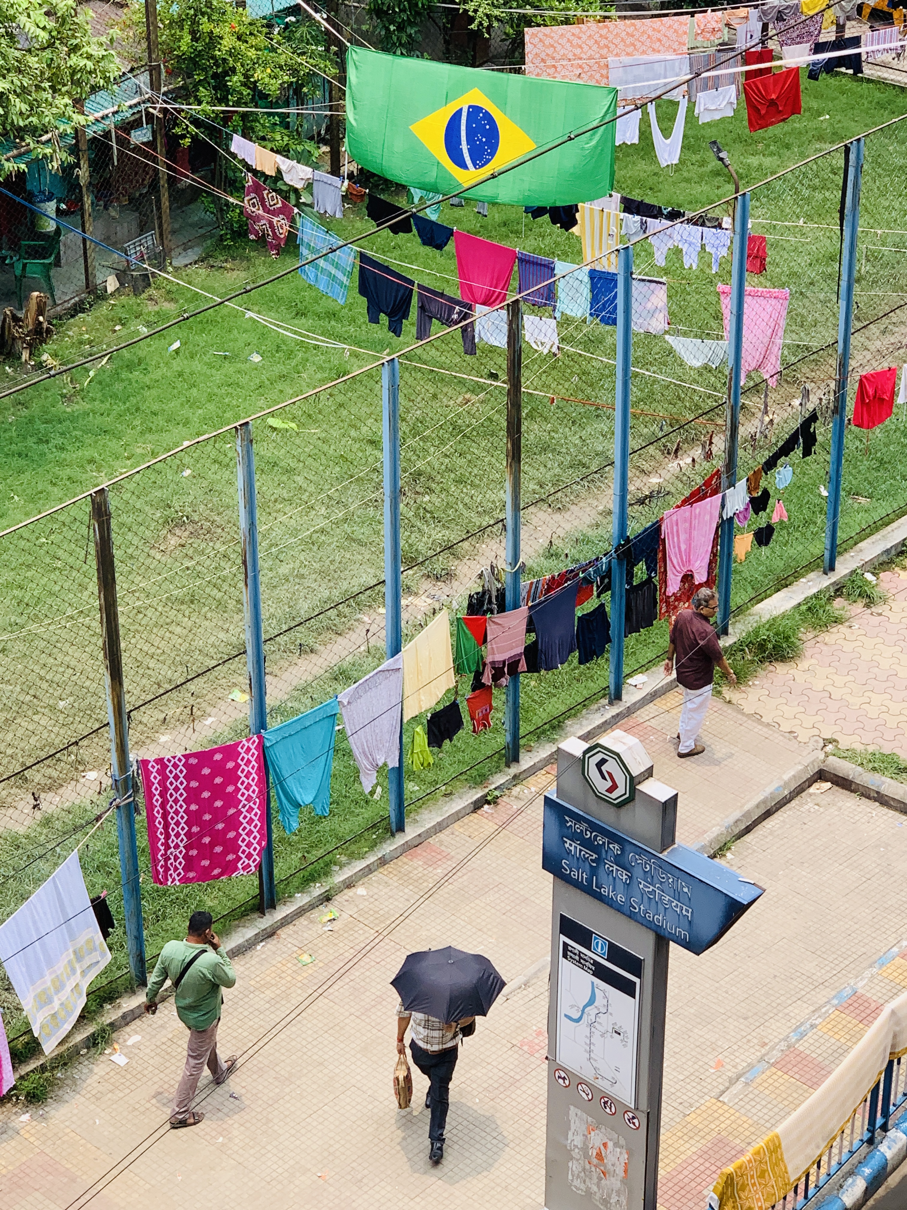 Brazil's flag flies above rows of washing outside the Salt Lake metro station [Chandrahas Choudhury/Al Jazeera]