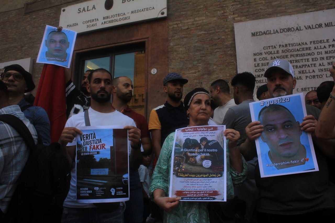 People, including family members, hold pictures of Abderrahim Fakir during a vigil in Bologna after his death during a police restraint [Dea Sibilla/Al Jazeera]