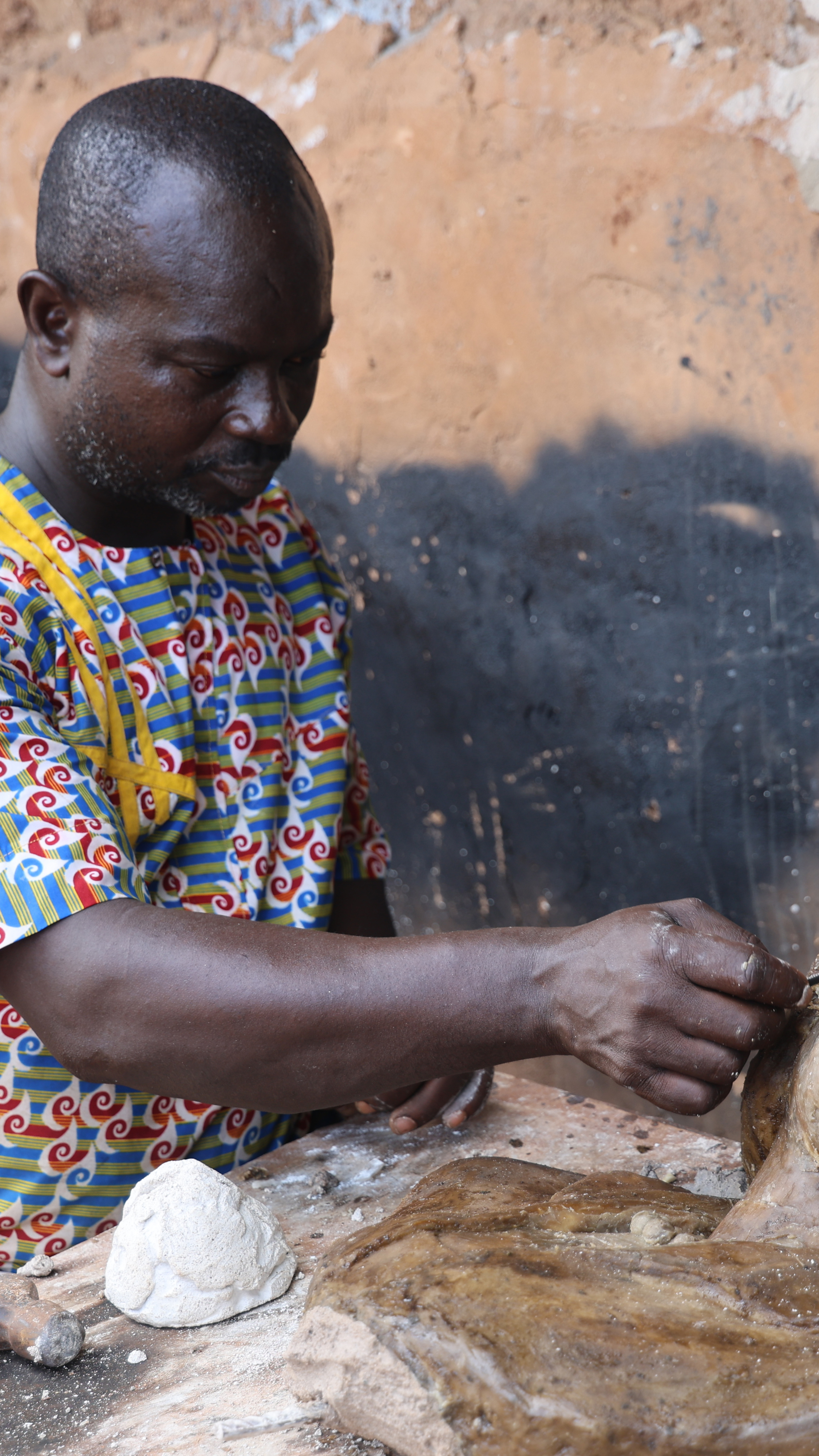Known as Double Chief, the artisan refines a bronze sculpture in his workshop on Igun Street