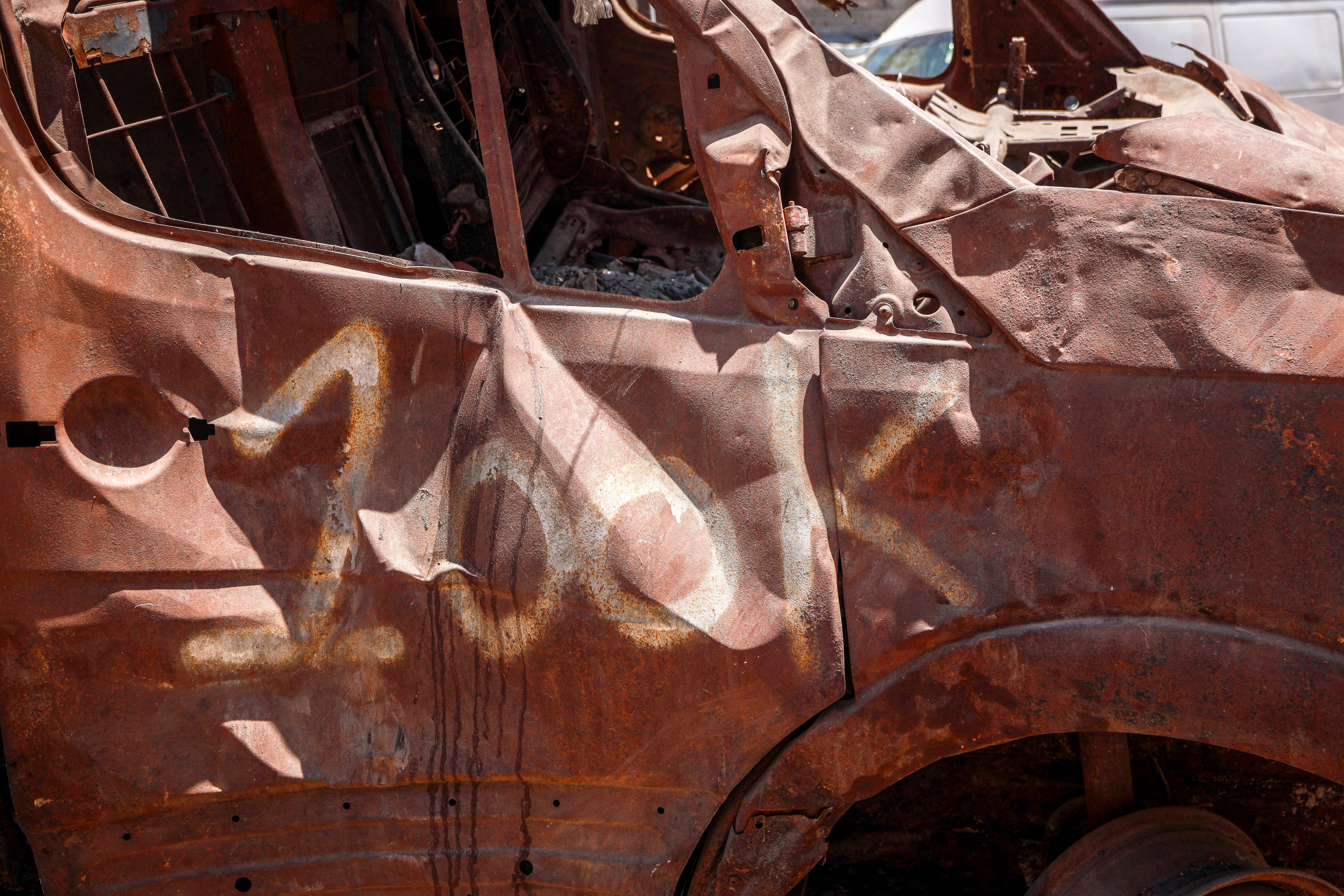 A burnt-out car bearing the graffiti 'LOOK' stands in Gaza City