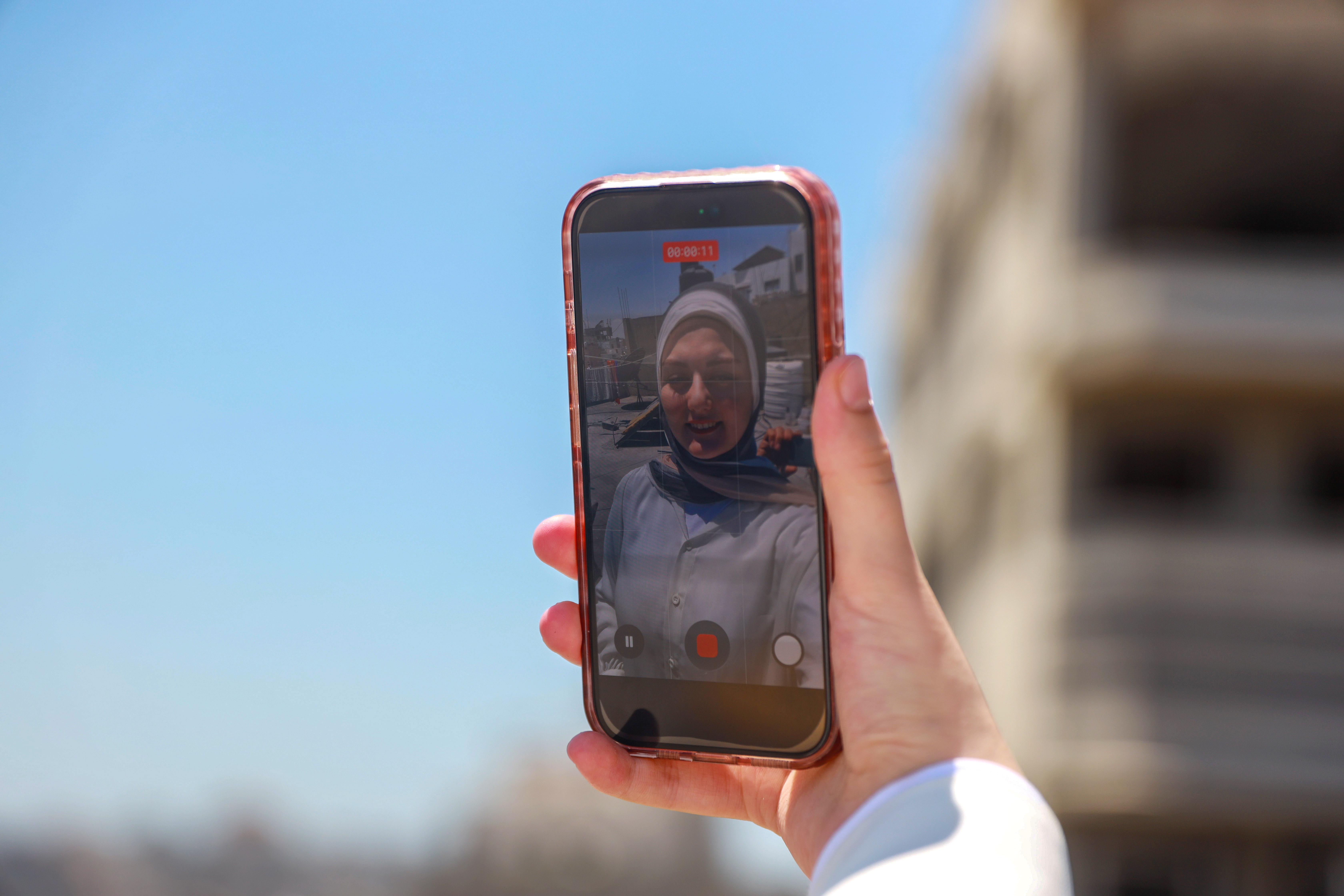 Eman Lulu records a video in Gaza City, where her phone has become both a lifeline and a tool for documenting daily life during Israel's genocide in Gaza