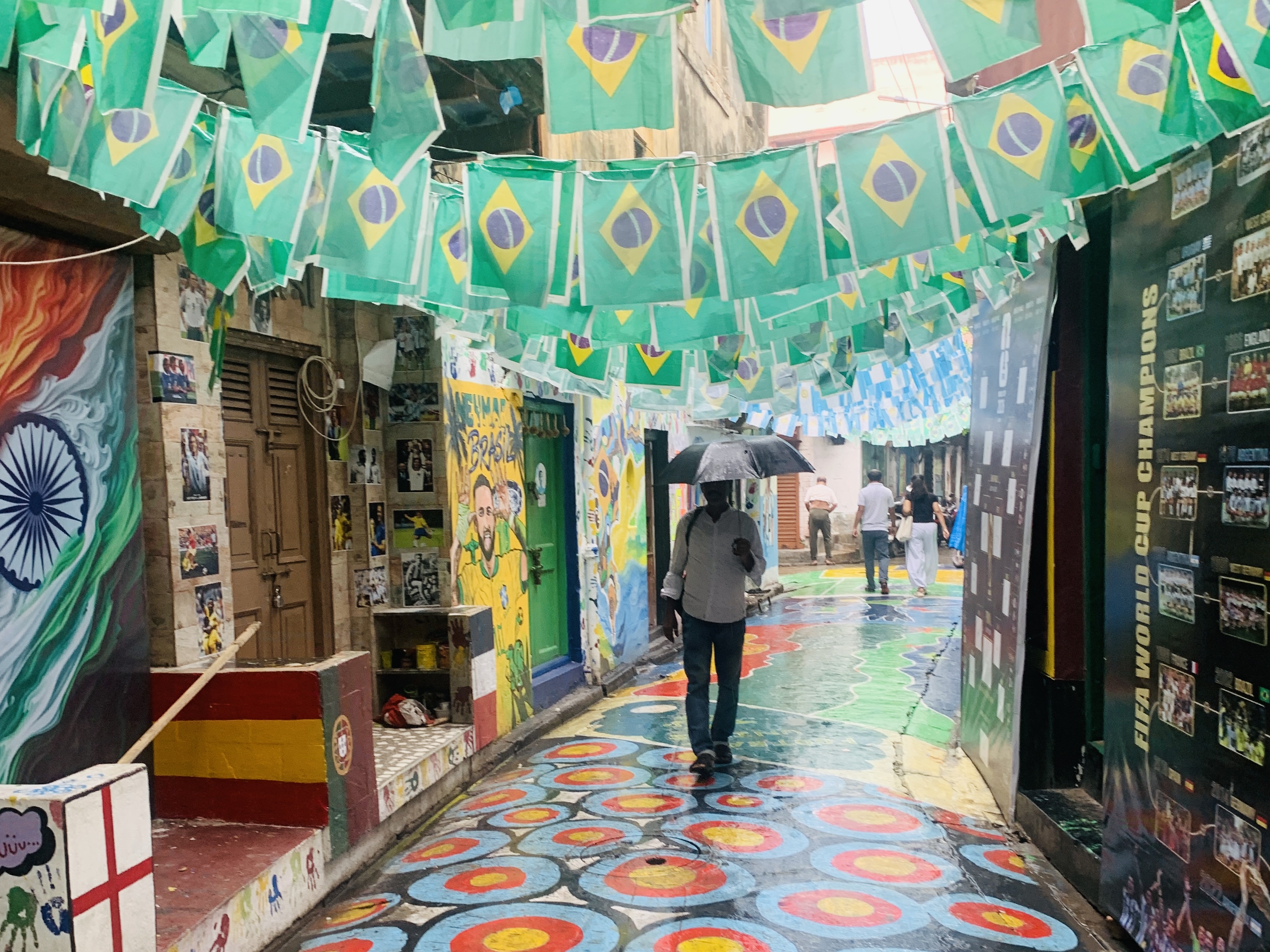 Football mania overshadowed by a Brazilian flag in Fakir Chakraborty Lane, aka FIFA Lane, in north Kolkata [Chandrahas Choudhury/Al Jazeera]