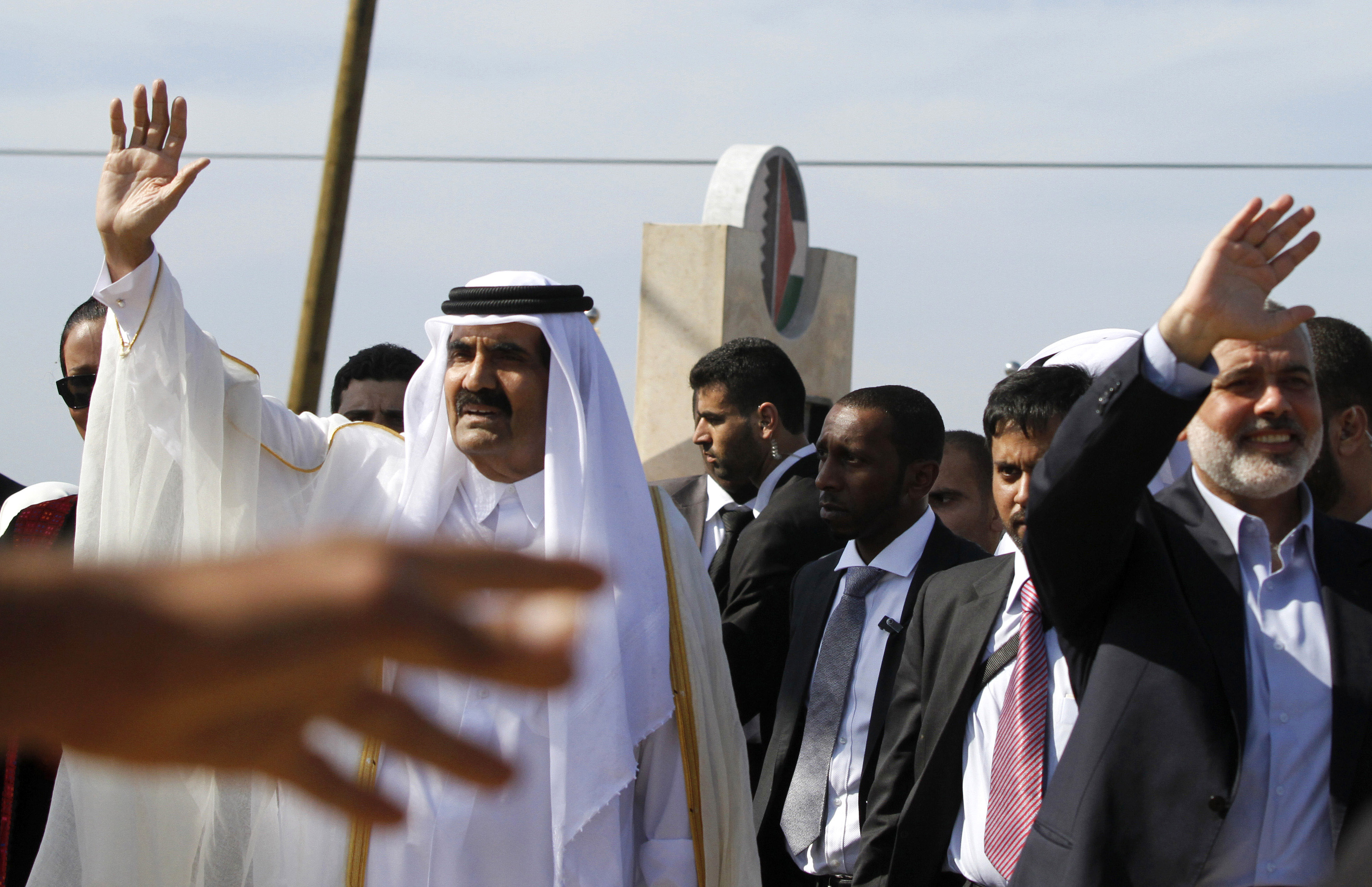 GAZA CITY, GAZA - OCTOBER 23: The Emir of Qatar Sheikh Hamad bin Khalifa al-Thani (L) and Hamas Prime Minister Ismail Haniyeh of the Palestinian National Authority wave to the crowd as they arrive to a cornerstone-laying ceremony of a Qatari funded rehabilitation center October 23, 2012 in Gaza City, Gaza. The Emir of Qatar received a hero's welcome in Gaza, becoming the first head of state to visit the Palestinian territory since the Islamist militant Hamas seized control there in 2007. (Photo by Hatem Moussa-Pool/Getty Images)