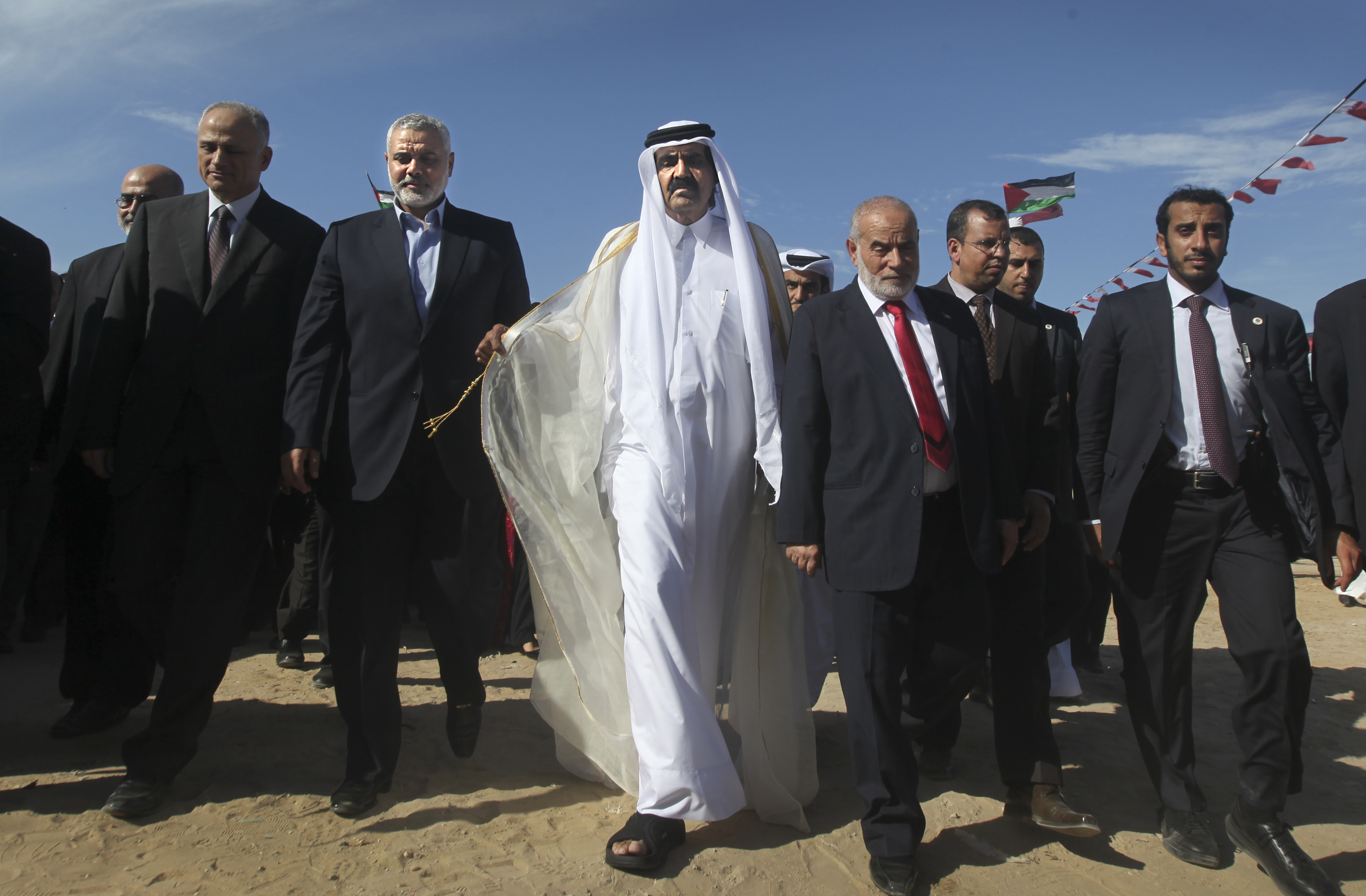 Hamas Prime Minister Ismail Haniyeh (3rd-L) of the Palestinian National Authority and the Emir of Qatar Sheikh Hamad bin Khalifa al-Thani (4th-L) arrive to a cornerstone-laying ceremony for Hamad in Khan Younis in the southern Gaza Strip