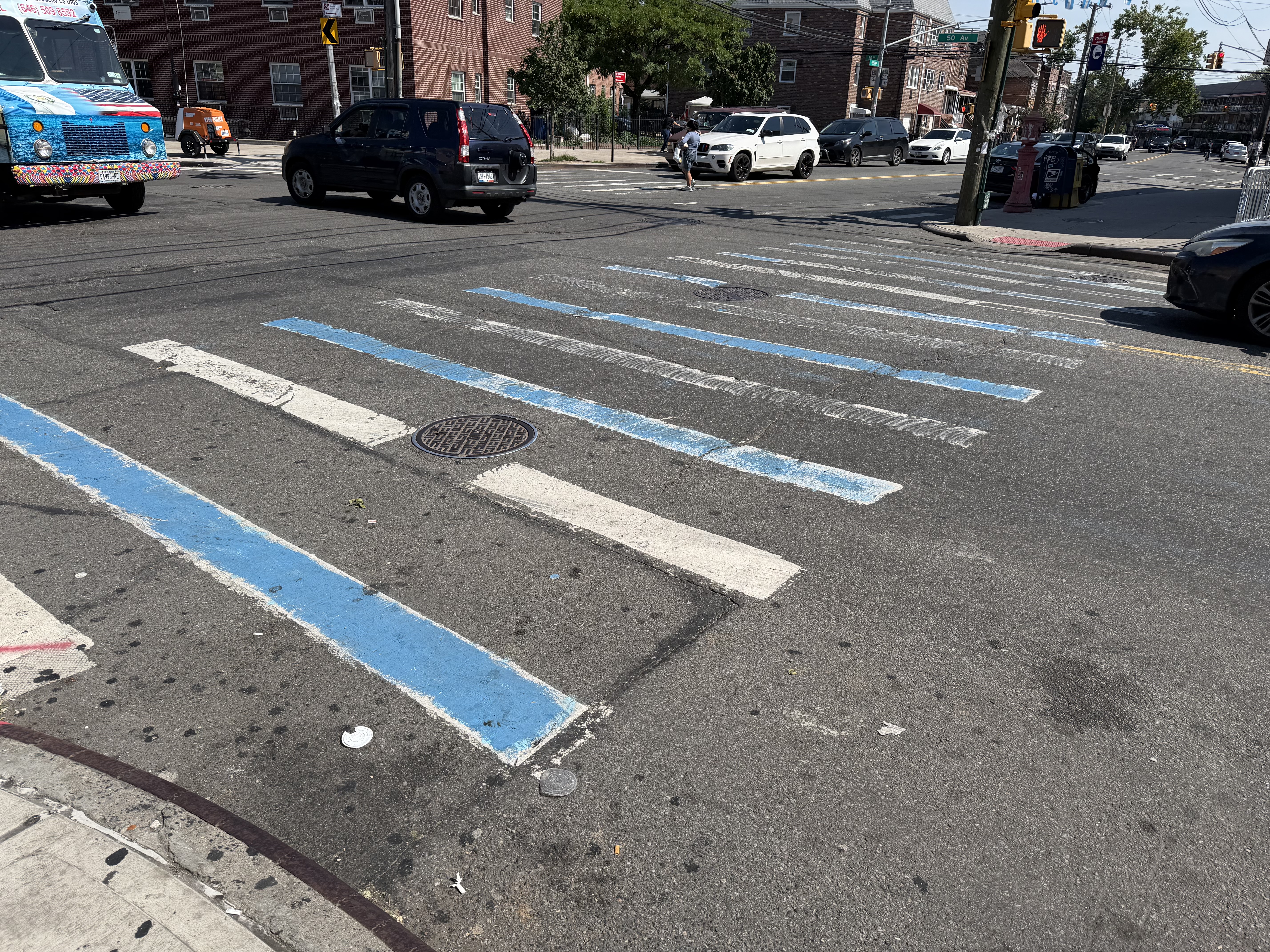 A crosswalk is painted in the colours of Argentina in Queens, NY