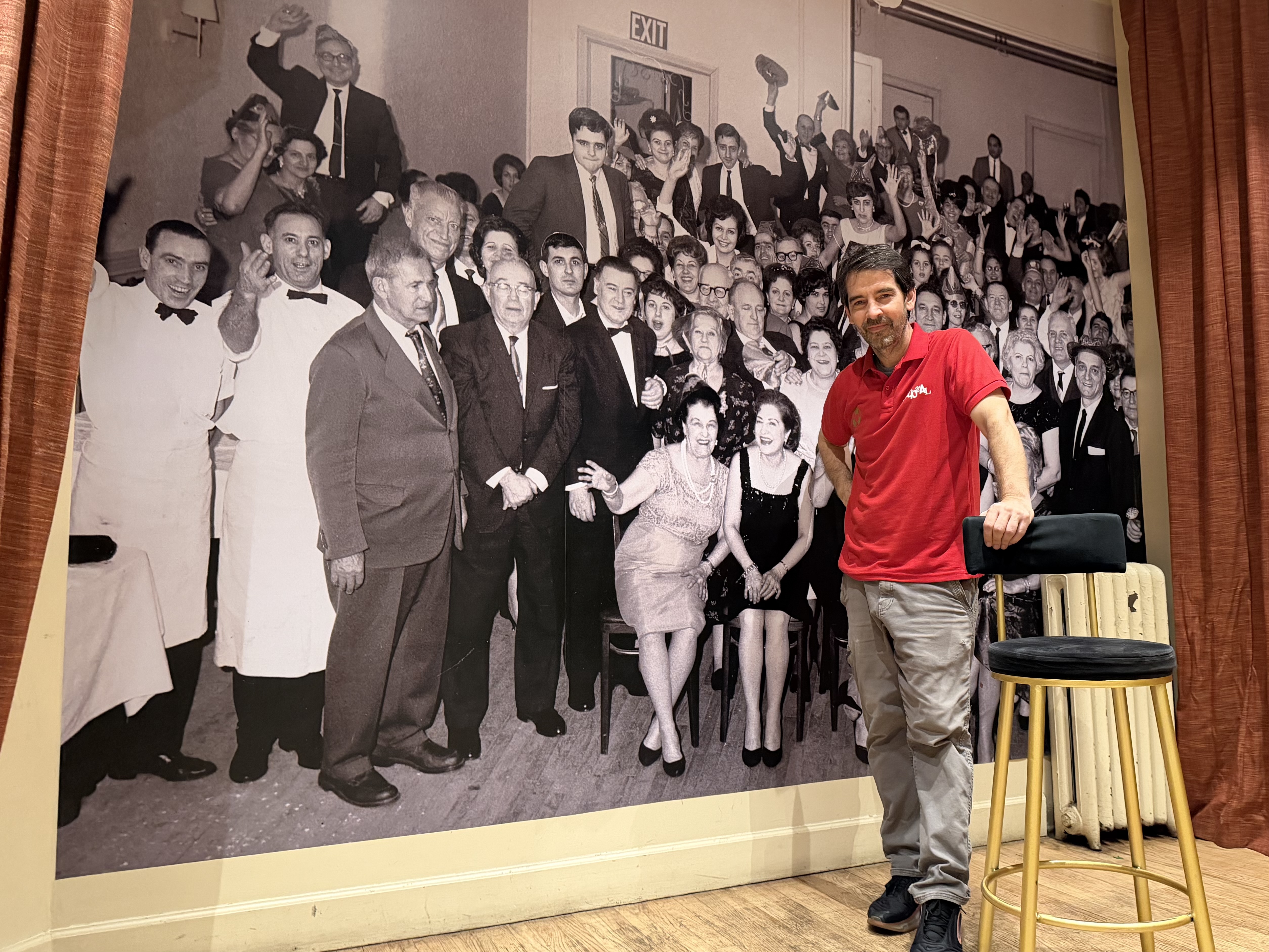 Robert Sanfiz stands in front of a historic photo at the Spanish Benevolent Society, La Nacional, in Manhattan