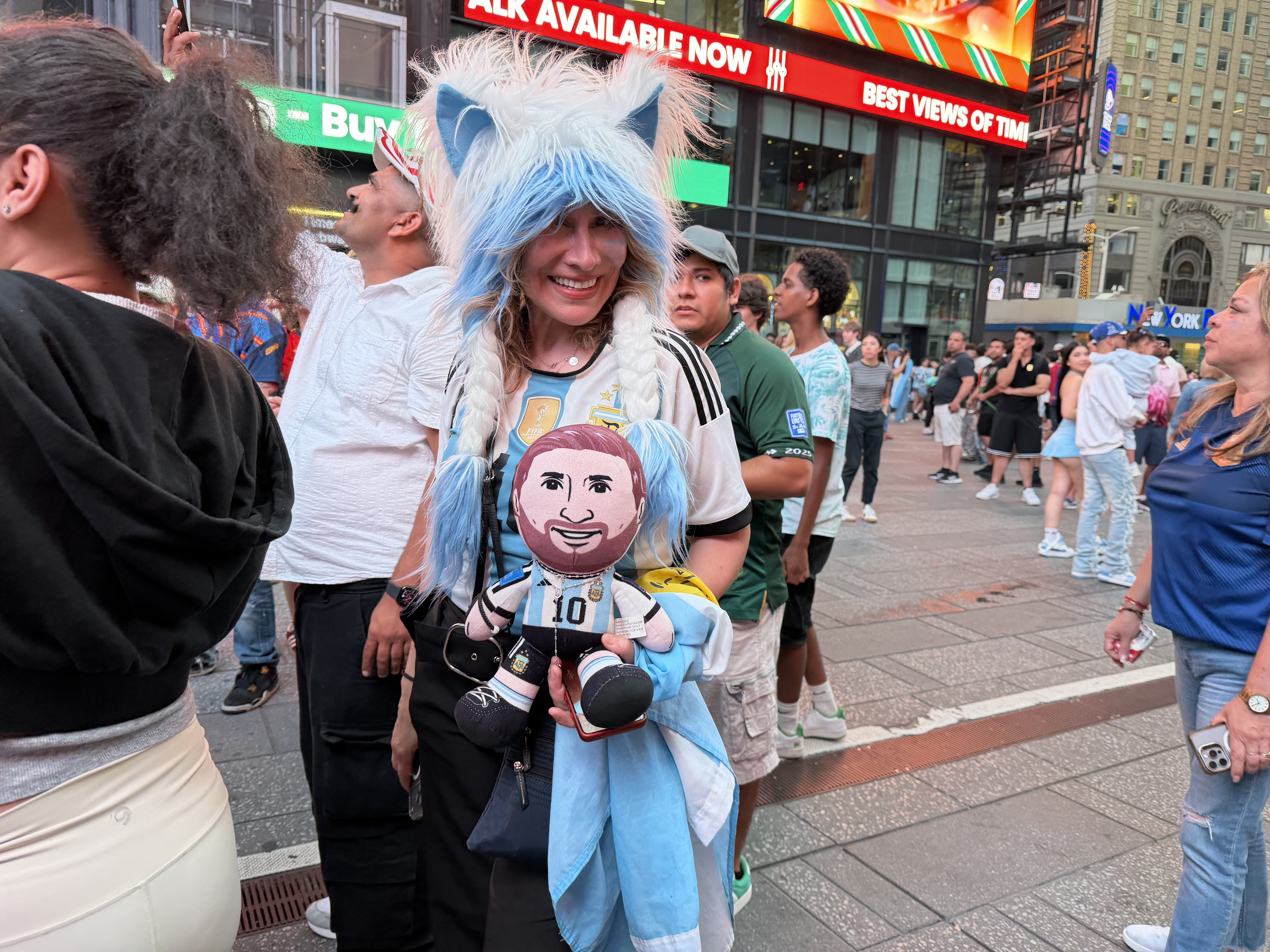 Argentina fan Lily holds a Lionel Messi doll in Times Square, New York City
