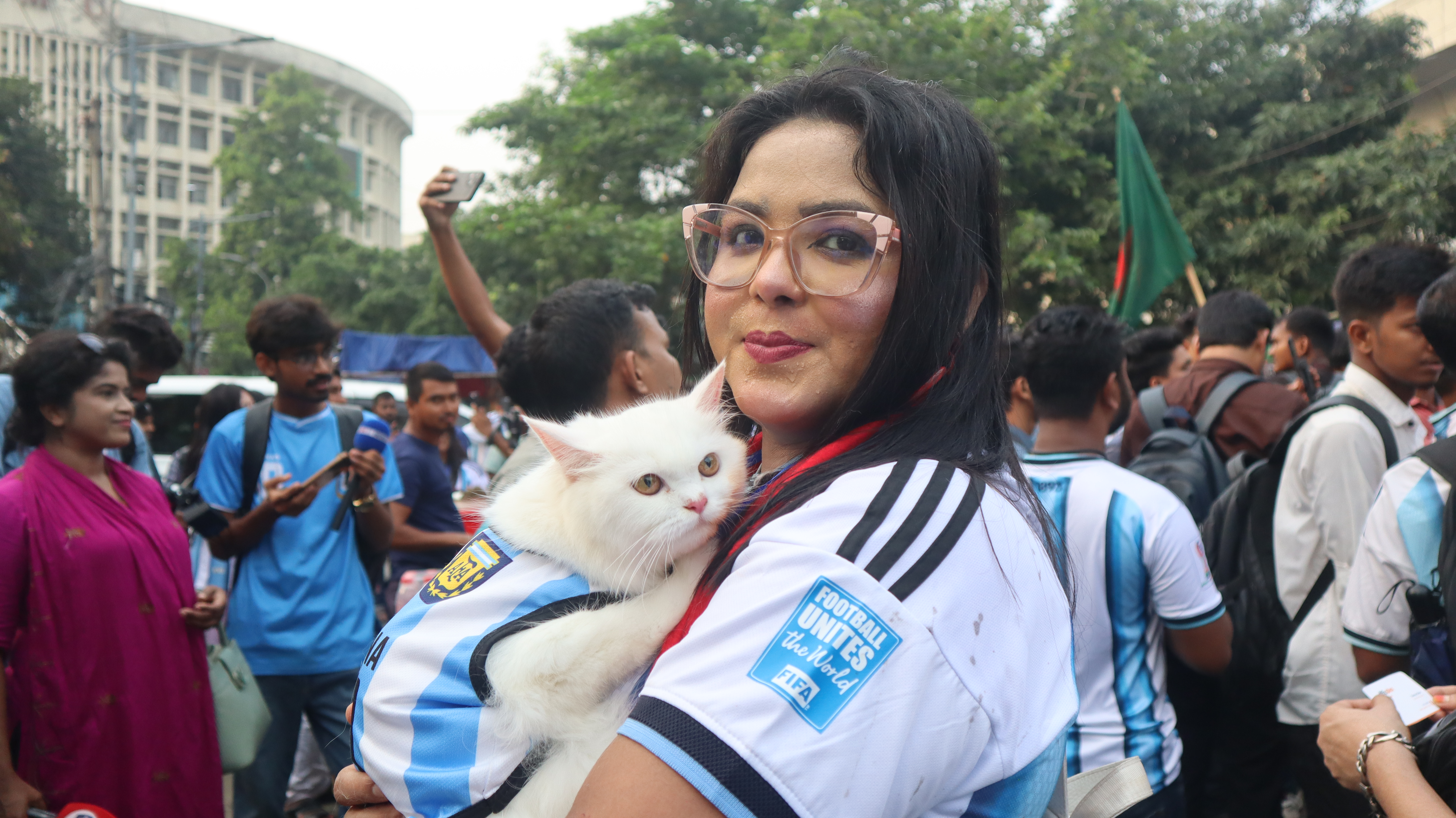 Argentina supporter Zubaida Islam Jerin with her pet cat, named Messi — also decked in an Argentina jersey [Masum Billah/ Al Jazeera]