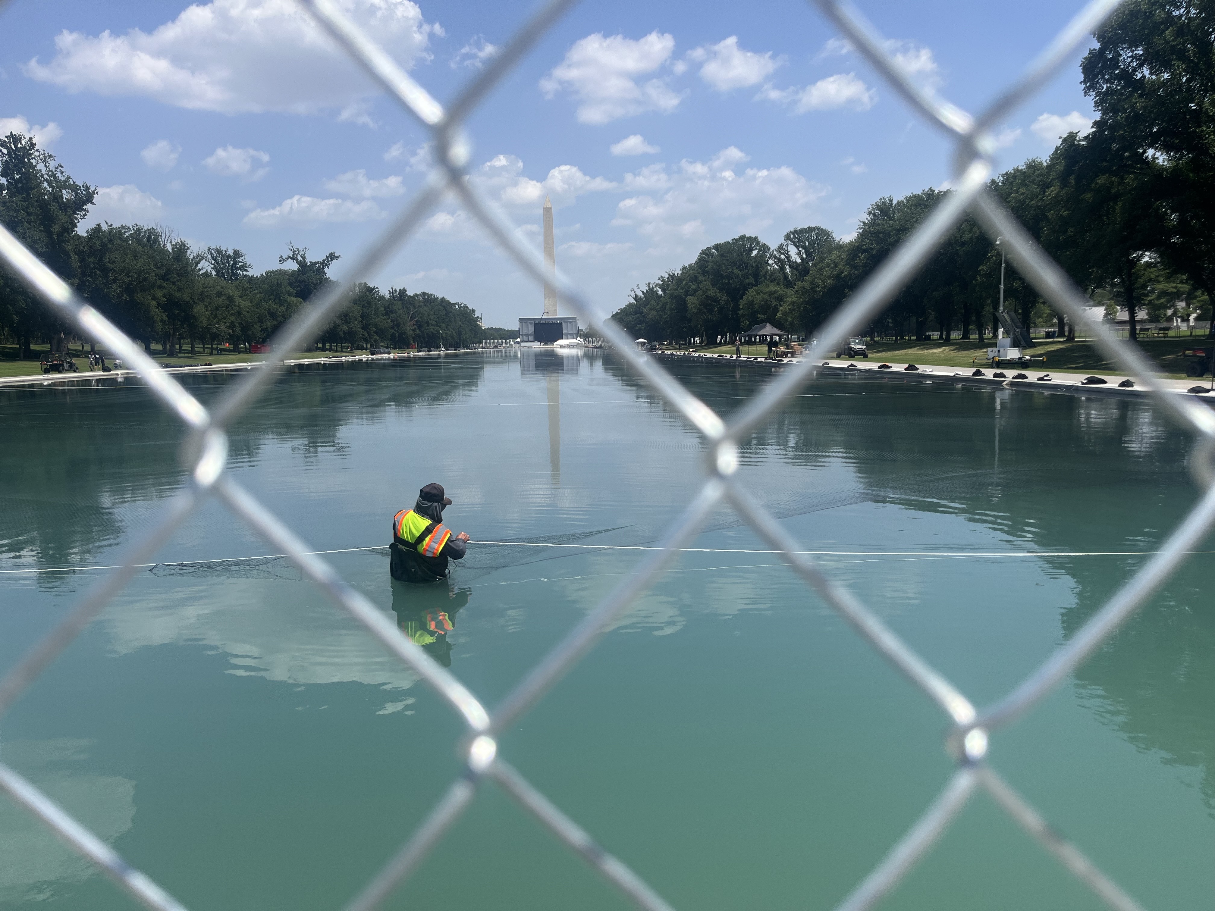 A person places nets in the Reflecting Pool