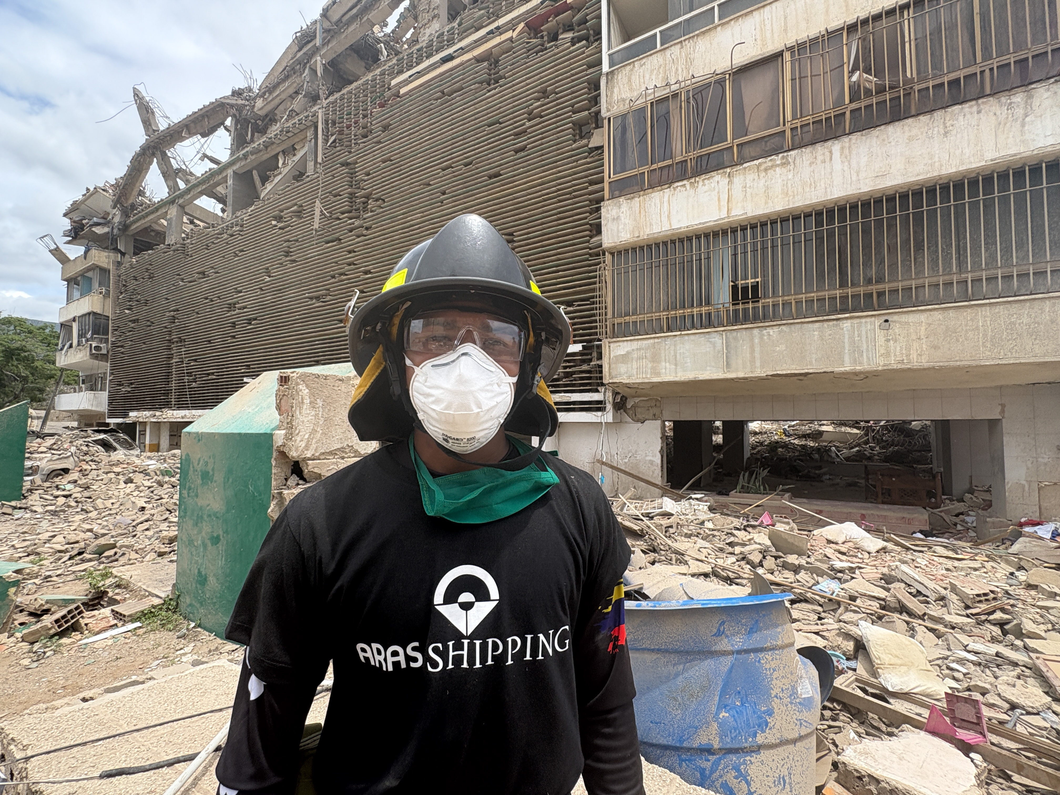 Volunteer firefighter Jeff Sombrito sifts through the rubble of the June 24 earthquake